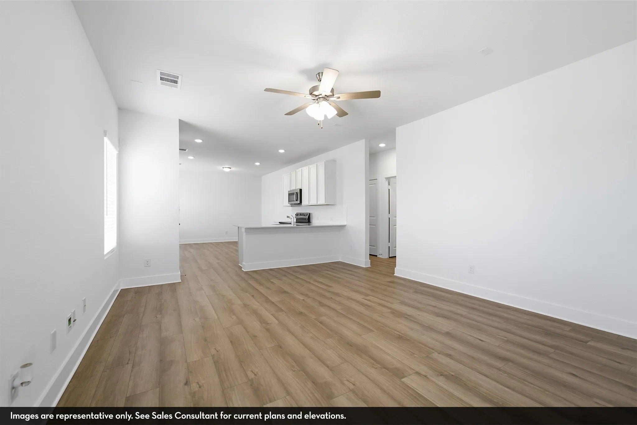 Wood-finish flooring throughout, bright white walls, recessed lighting, and a ceiling fan with brushed nickel accents