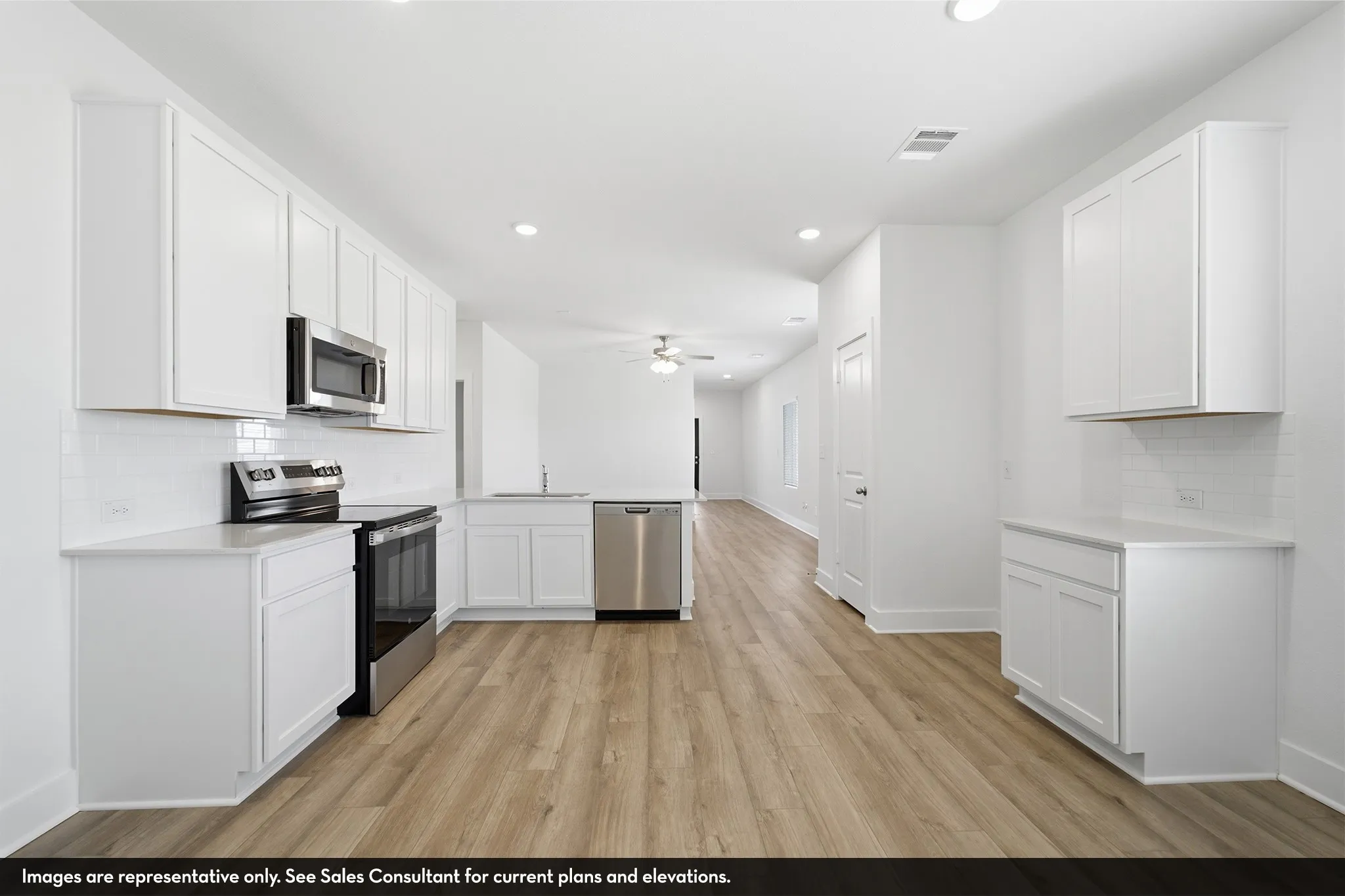 Kitchen featuring white cabinetry, stainless steel appliances, white subway tile backsplash, light countertops, and wood-finish flooring
