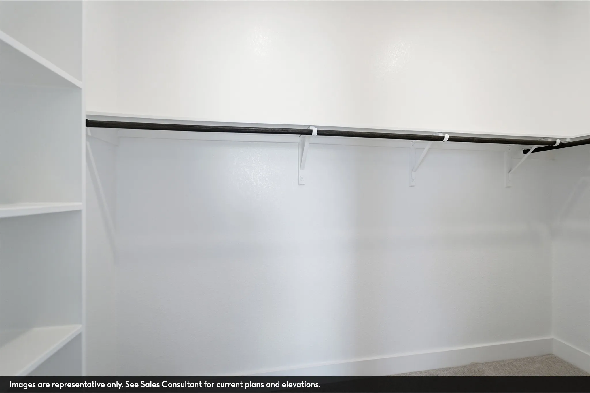Built-in shelving, white walls, black garment rod, wall-mounted brackets, light carpet