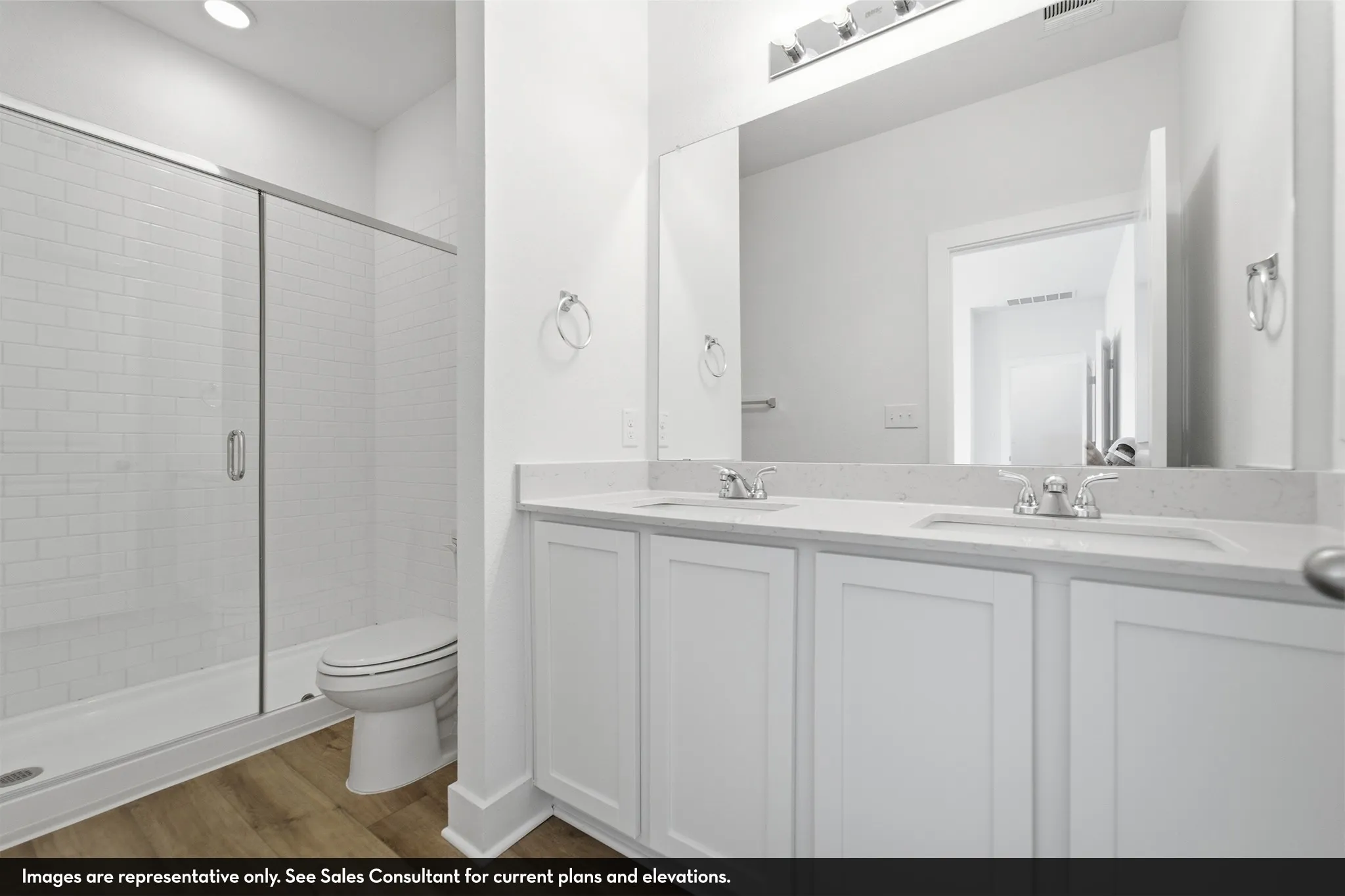 Dual sink vanity with white cabinetry, light-toned countertop, and chrome fixtures