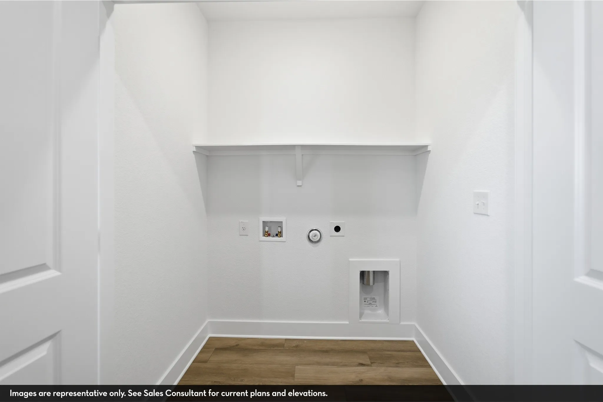 Laundry area with built-in shelving, wood-finish flooring, and white paneled doors