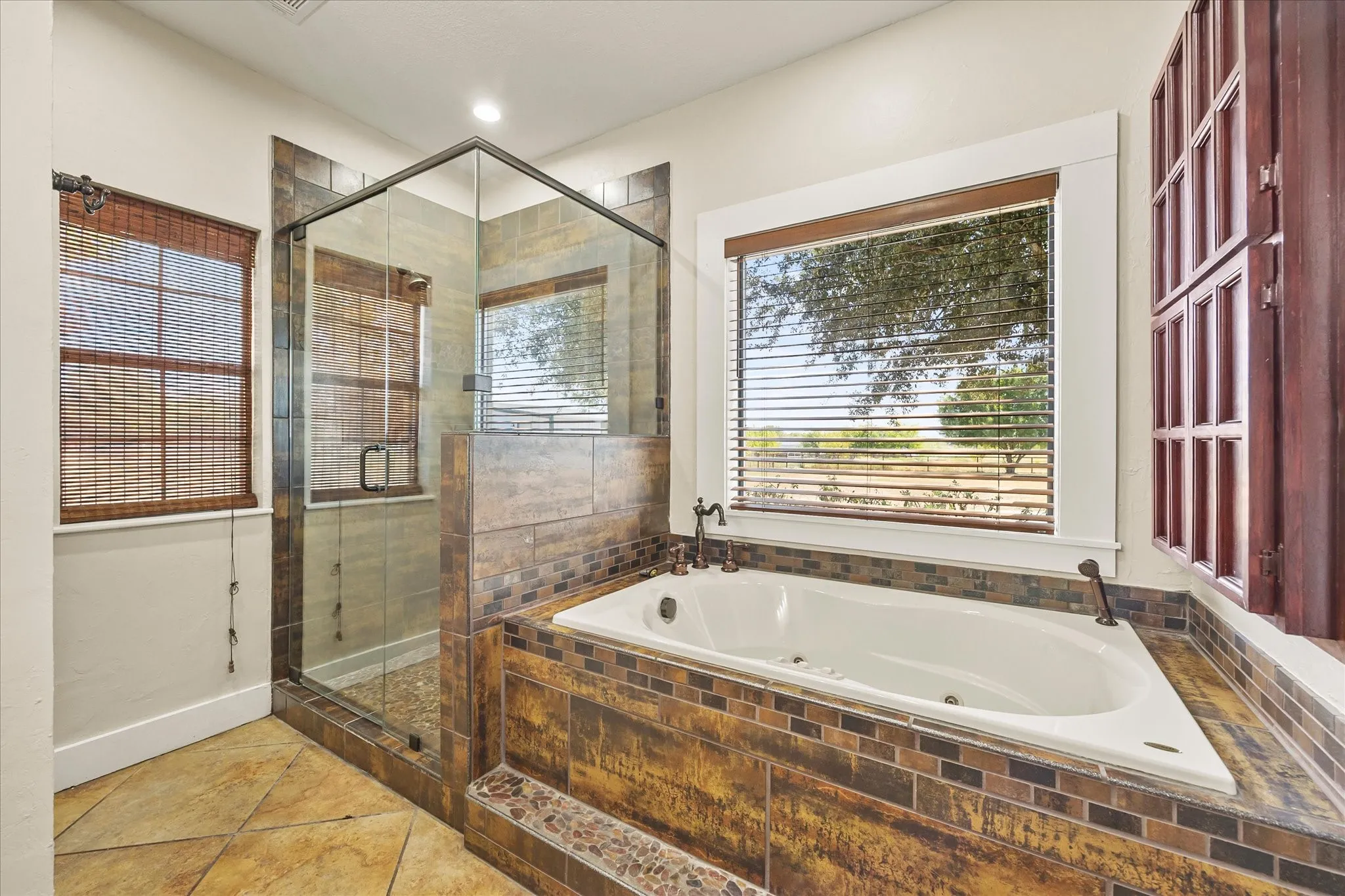 Oversized soaking tub and shower, granite counters, tile floors, second primary closet.