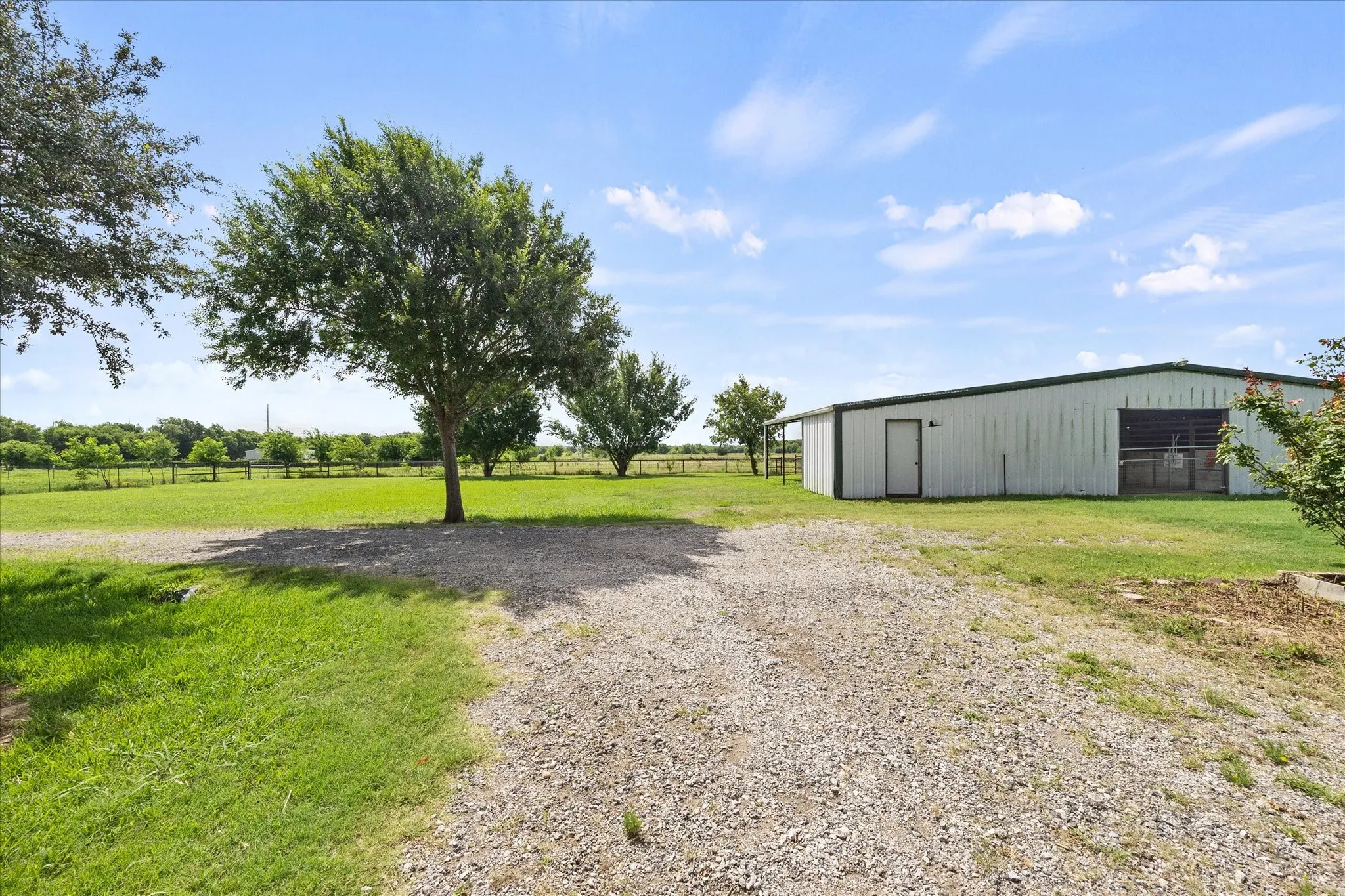 Barn is thoughtfully designed with five stalls, hay storage, work room, covered storage area.