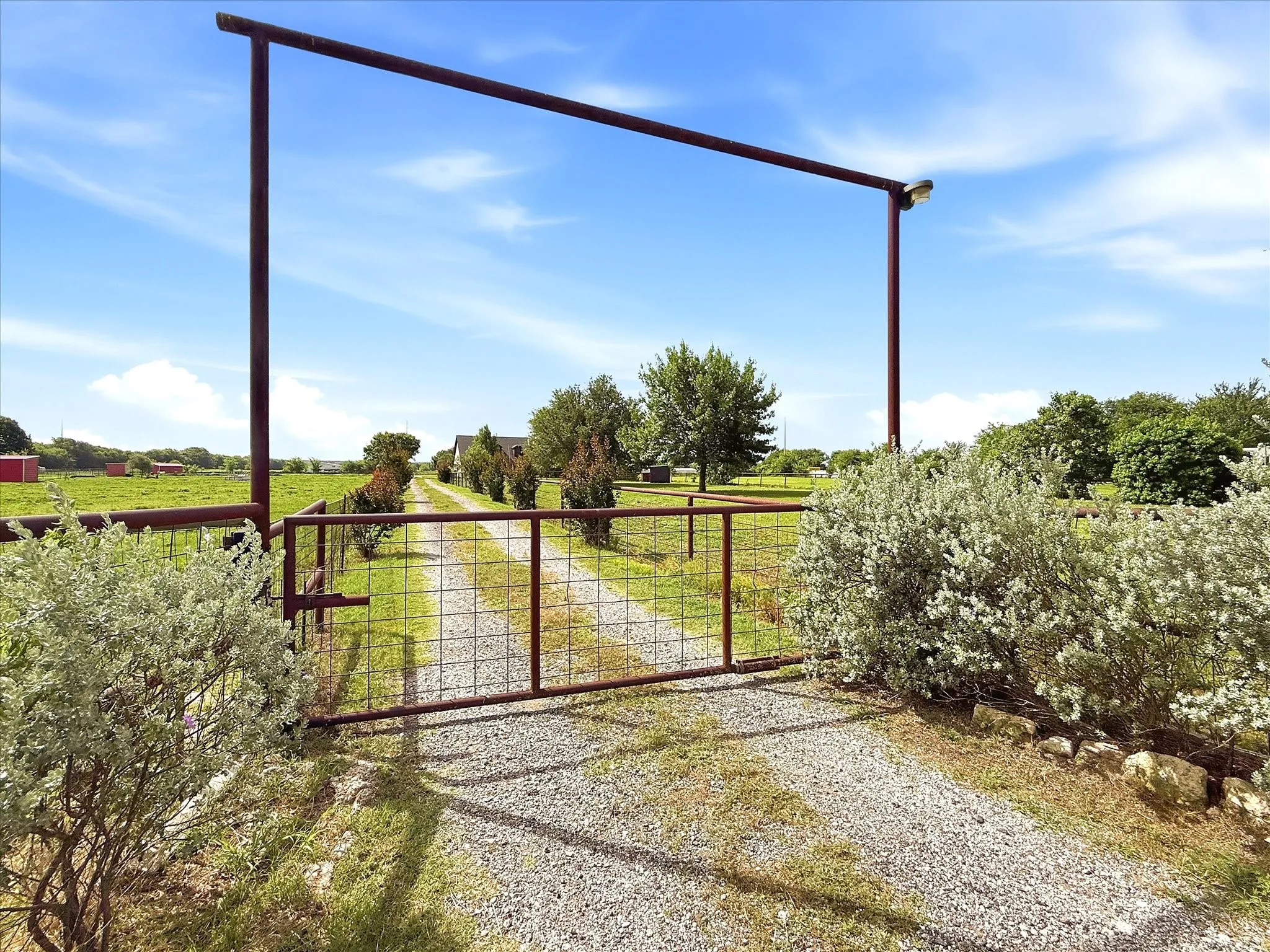 Gated entry and long driveway lead to the home, barn and pastures.