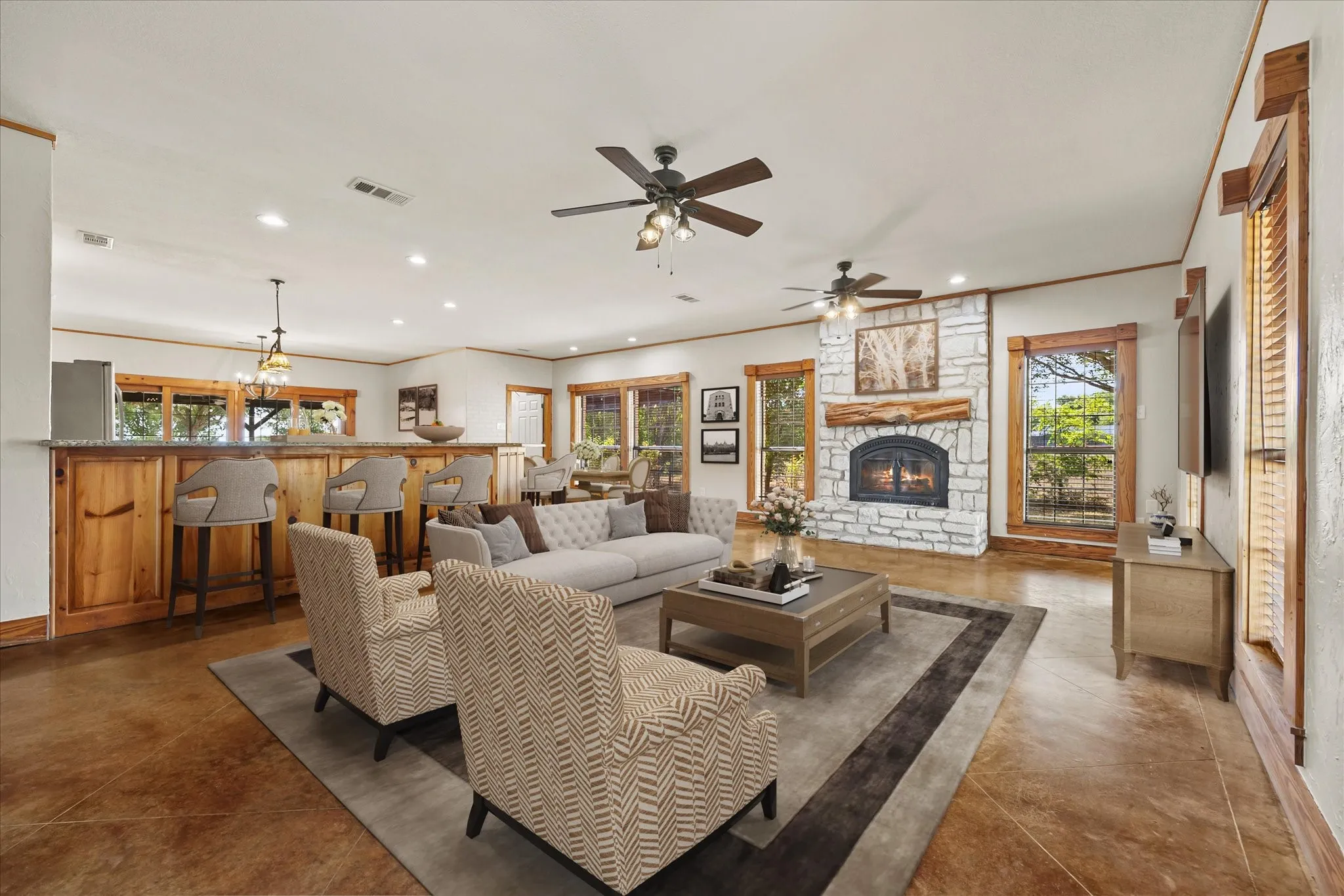 Virtually staged. Open concept living featuring stone fireplace with gas starter and easy-care stained concrete floors throughout living areas and master suite.
