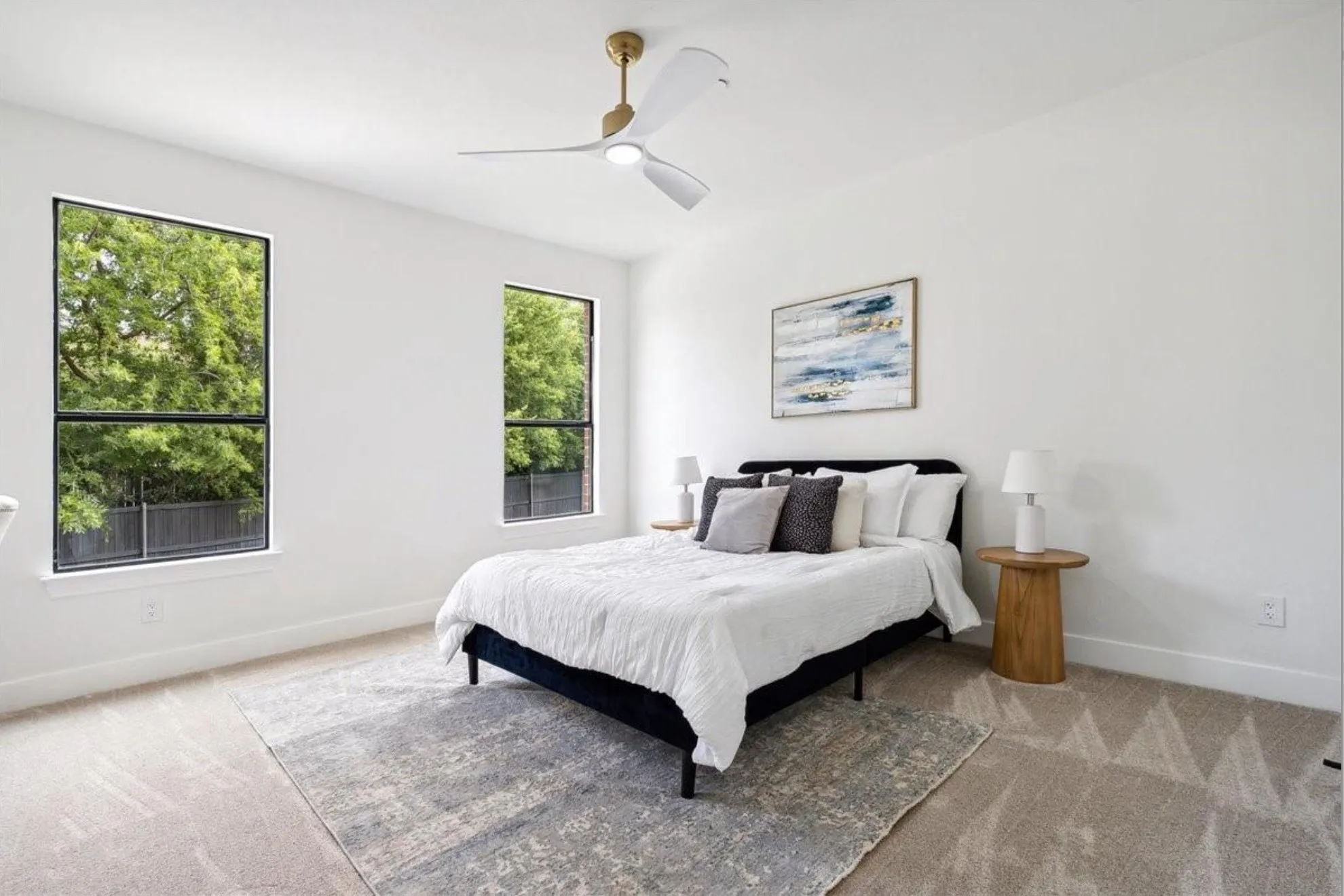 Recessed lighting, light gray carpet, and two large windows with black frames