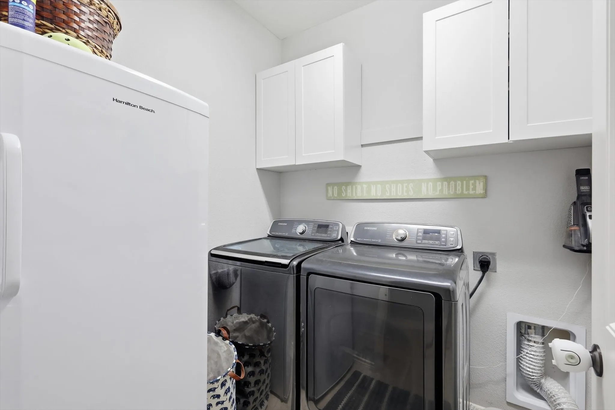 A laundry with cabinets and space for a full size washer and dryer