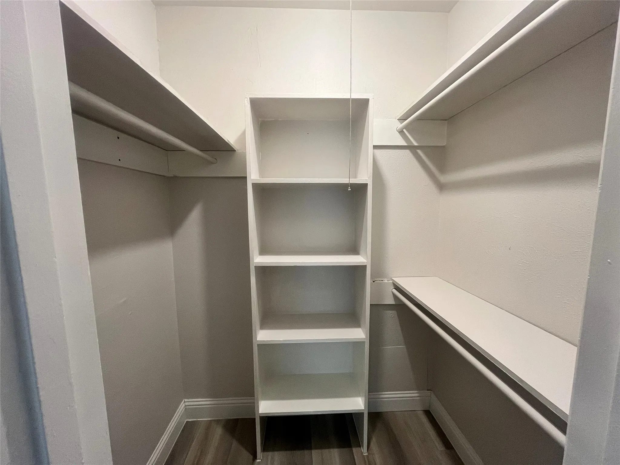 Custom shelving system with multiple storage rods, built-in shelves, and wood-finish flooring