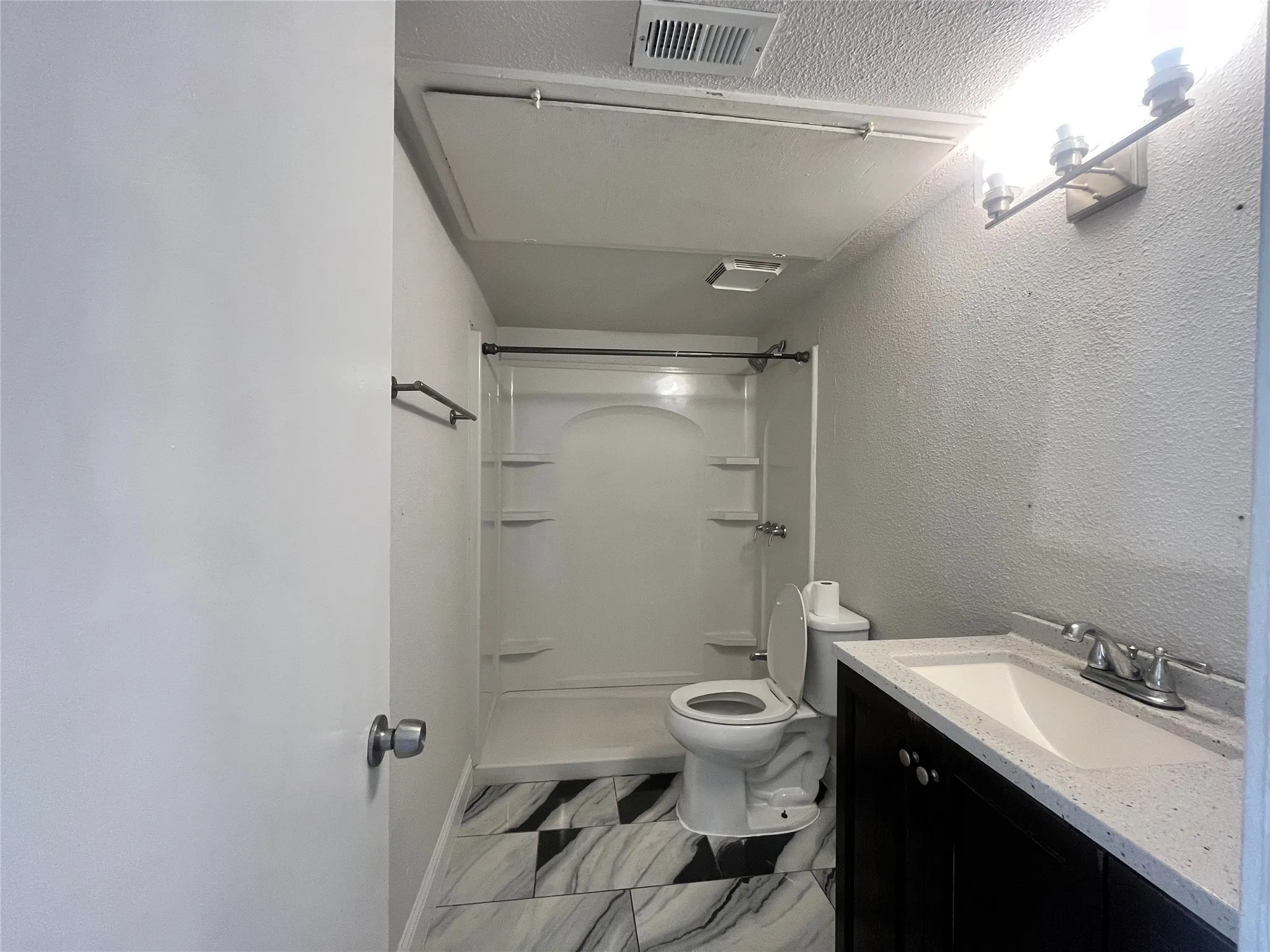 Modern vanity with integrated sink, black cabinetry, and a light-toned countertop