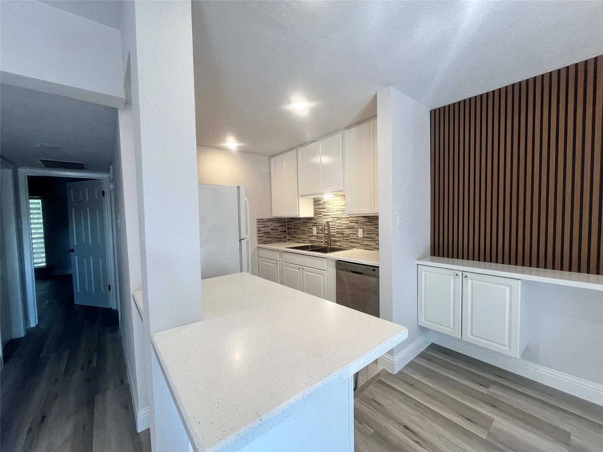 Kitchen featuring white cabinetry, light-toned countertops, a tile backsplash, and stainless steel appliances