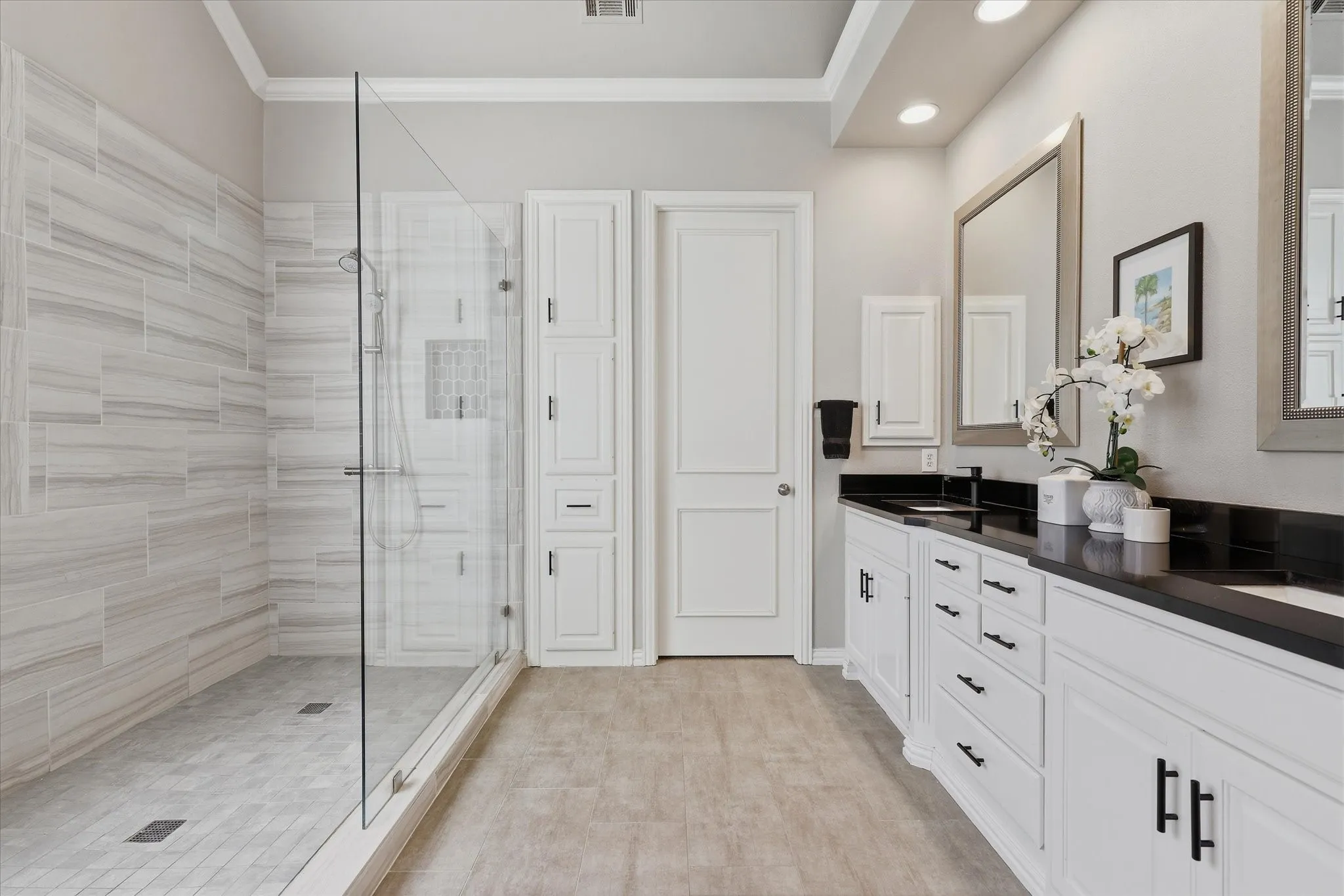 A massive glass-enclosed shower, dual sinks and abundant storage continue the clean-lined feel in the well-appointed primary bath.
