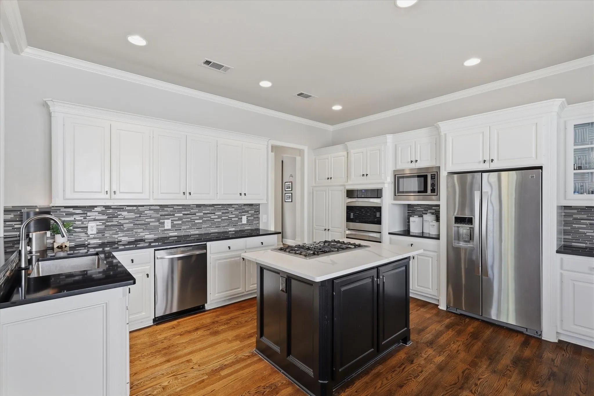 A gas cooktop, double ovens and generous counter space make it equally suited to everyday meals and entertaining.