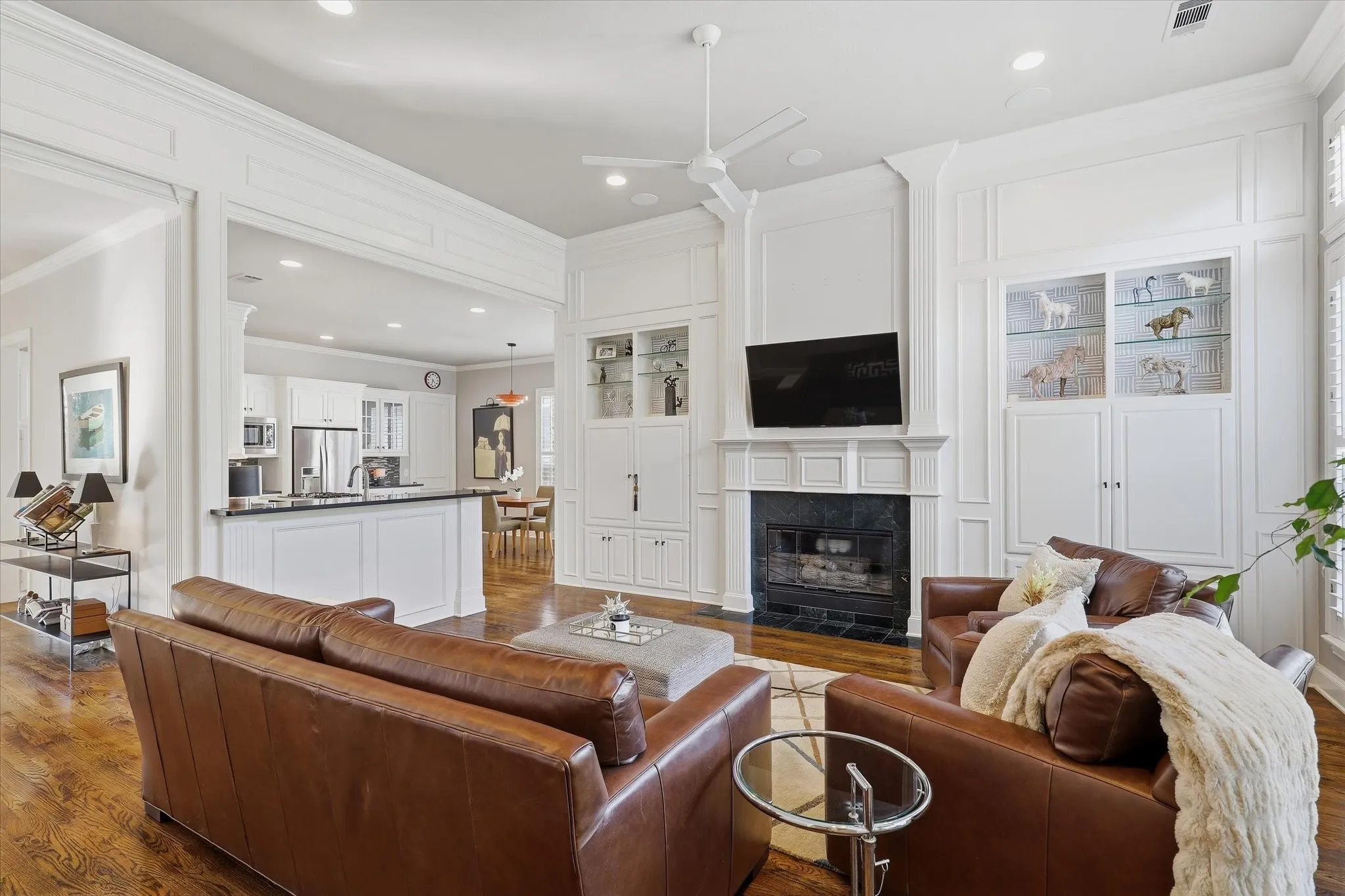 A fireplace with a floor-to-ceiling mantel surround and built-in cabinetry anchors the room, adding warmth and architectural interest.