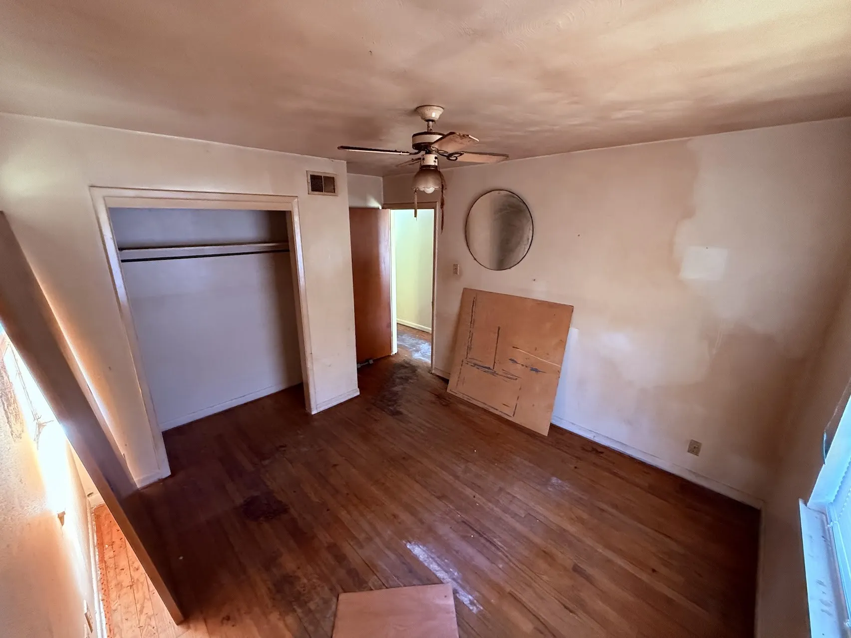 Hardwood flooring, ceiling-mounted fan, and built-in closet with hanging rod