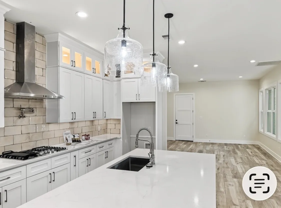 White shaker cabinetry with illuminated upper glass-front cabinets