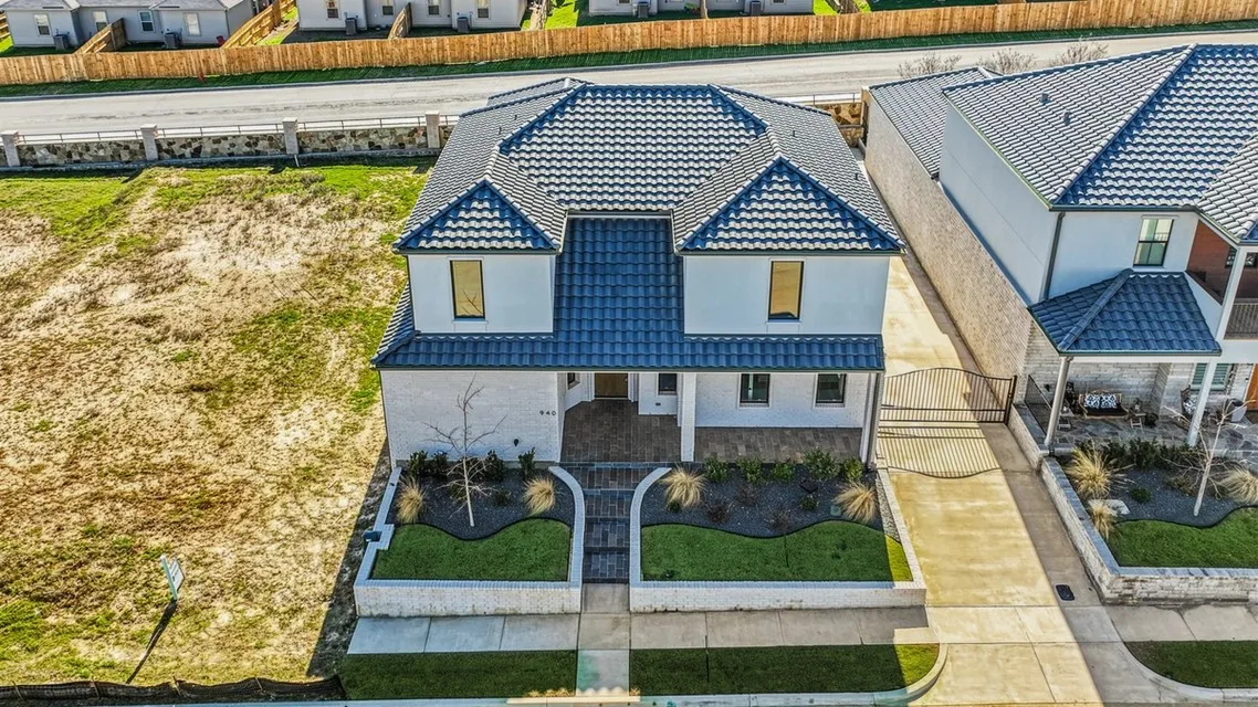 Contemporary exterior with a blue tile roof, white stucco facade, and an integrated two-car driveway