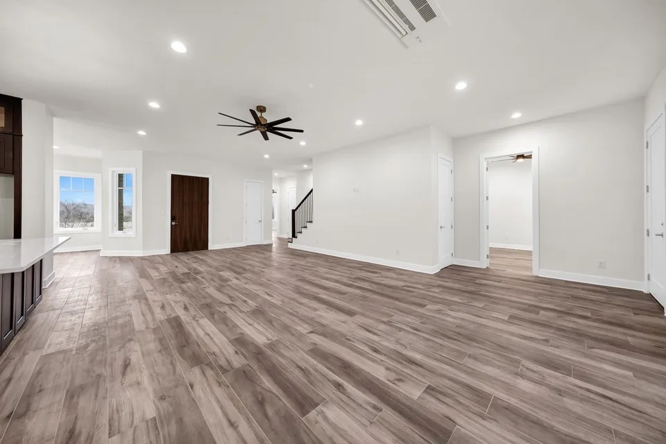 Spacious interior with wood-finish flooring, recessed lighting, and a contemporary ceiling fan