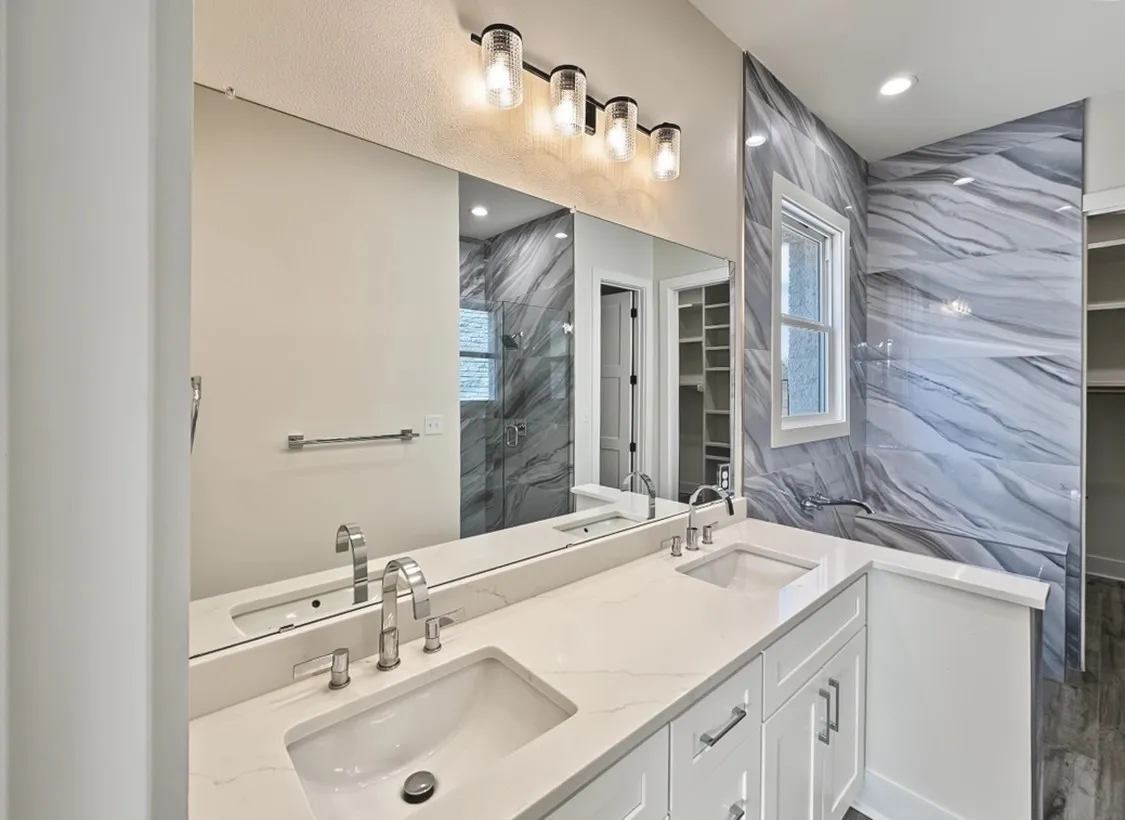 Dual undermount sinks, chrome fixtures, and a white vanity with panel-front cabinetry
