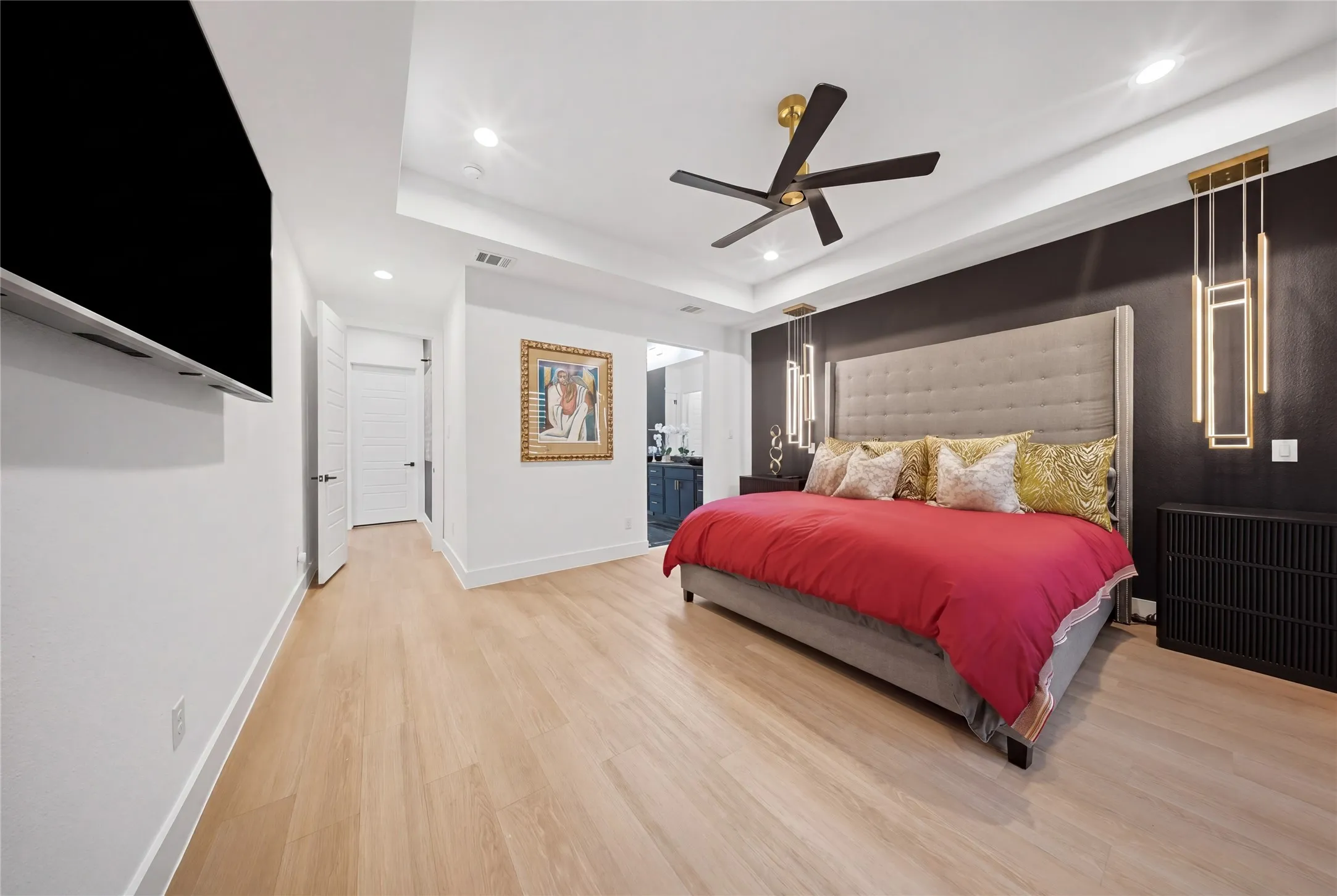 Wood-finish flooring, recessed lighting, and a tray ceiling with a modern ceiling fan