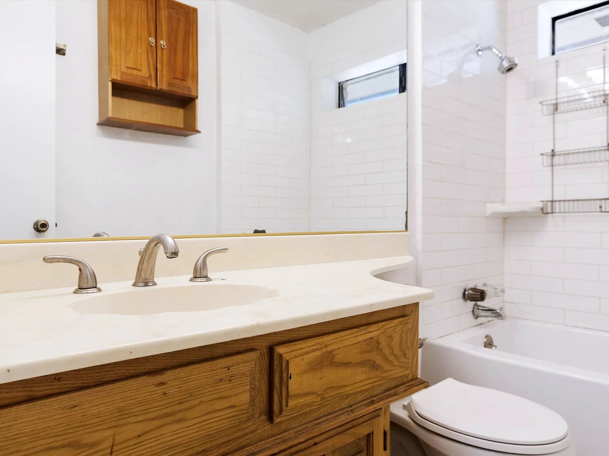 Vanity with wood-finish cabinetry, integrated sink, and brushed nickel faucet