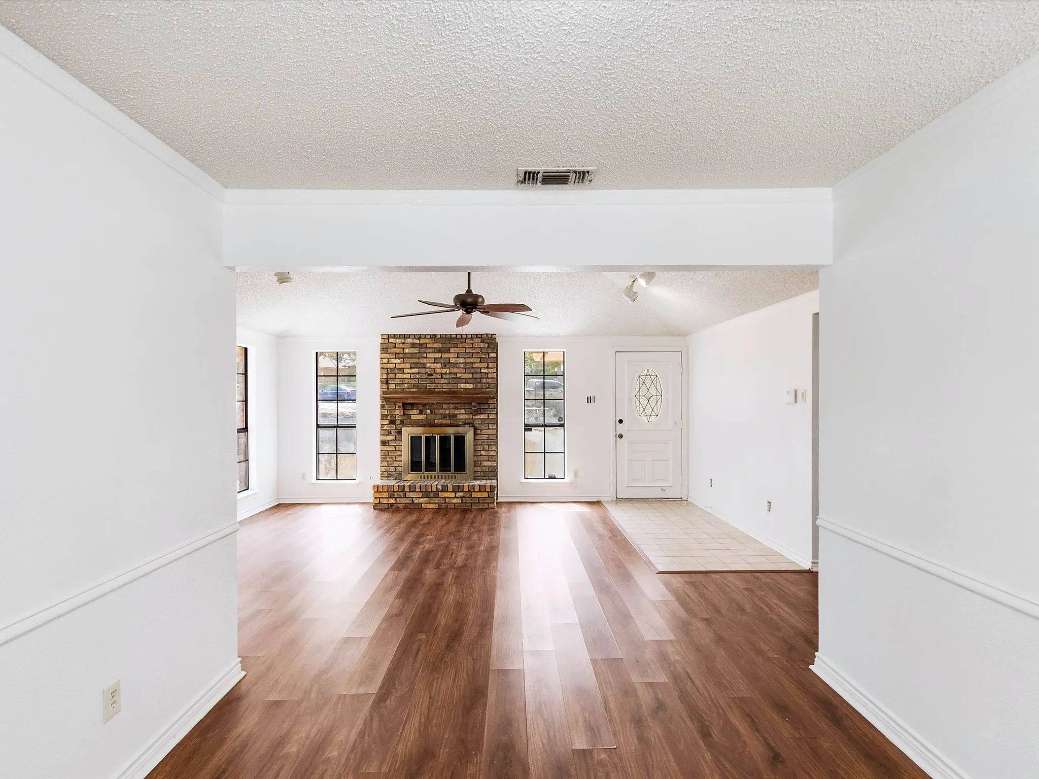 Wood-finish flooring throughout, complemented by a brick-faced fireplace