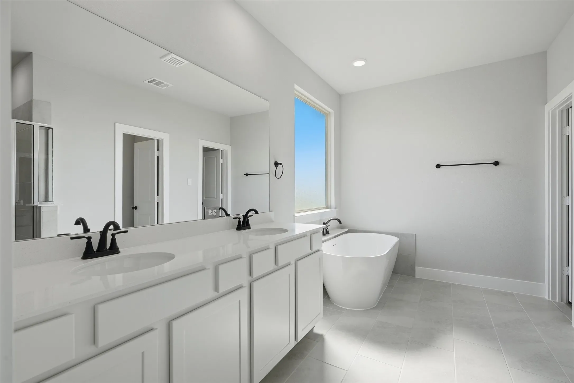 Dual vanity with solid surface countertop, undermount sinks, and matte black fixtures