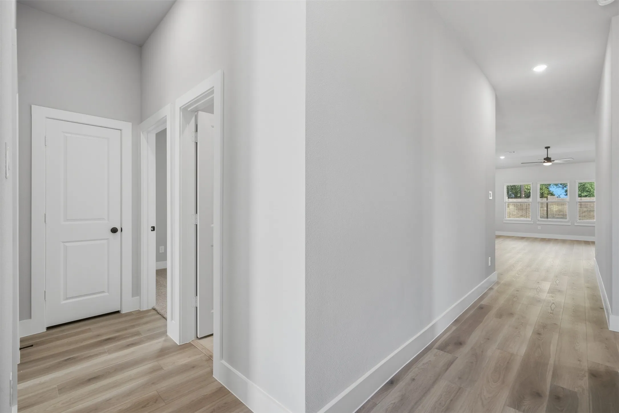 Wood-finish flooring throughout, recessed lighting, and white trim