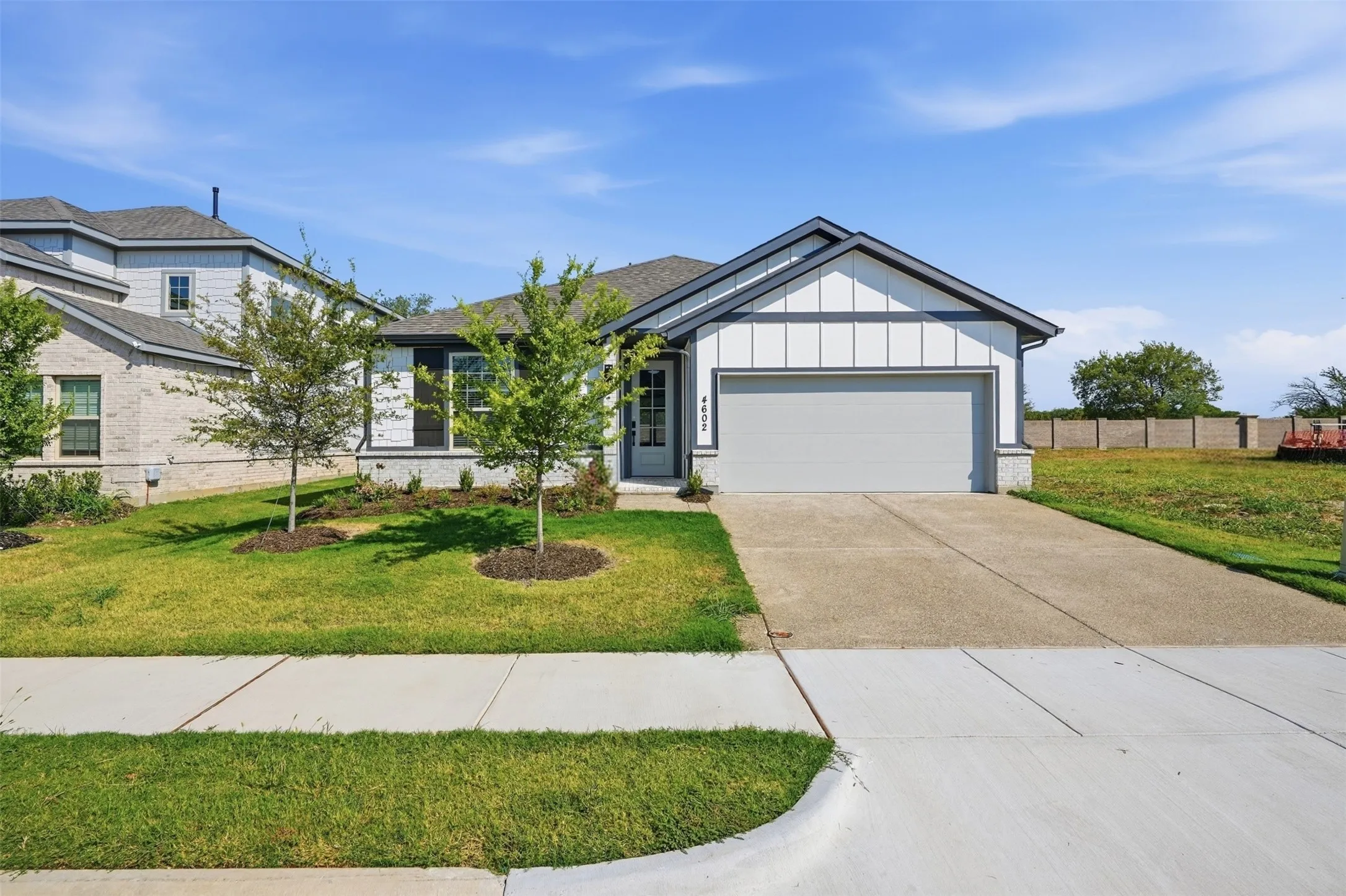 Contemporary exterior featuring board and batten siding, a prominent two-car garage, and a concrete driveway