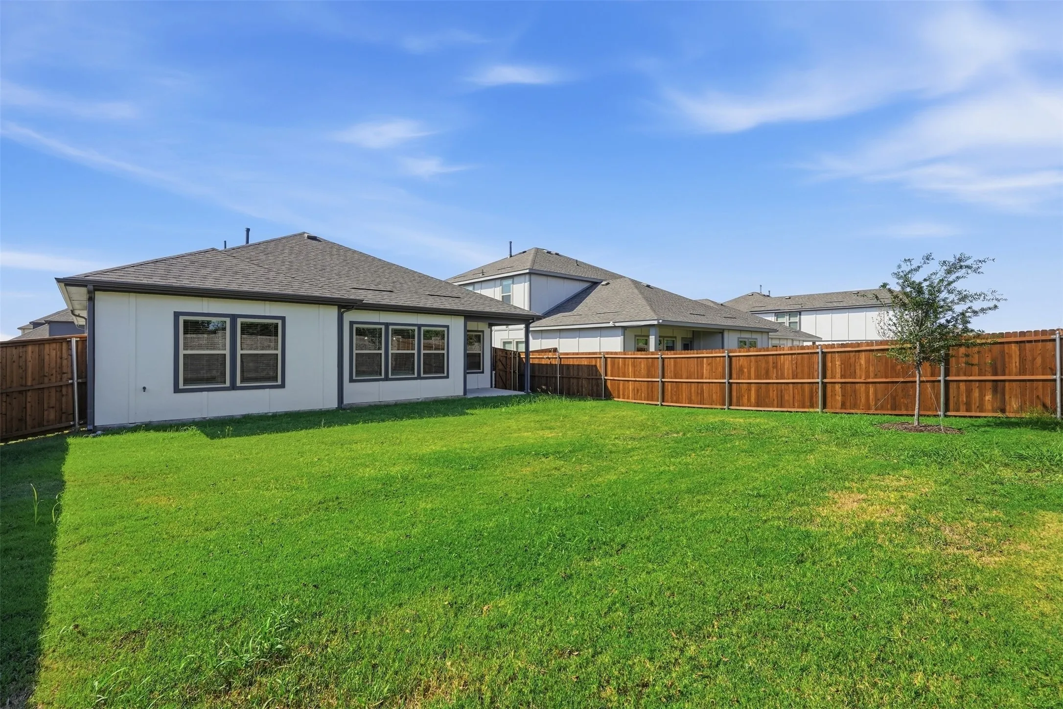 Expansive green lawn with a newly installed wood fence