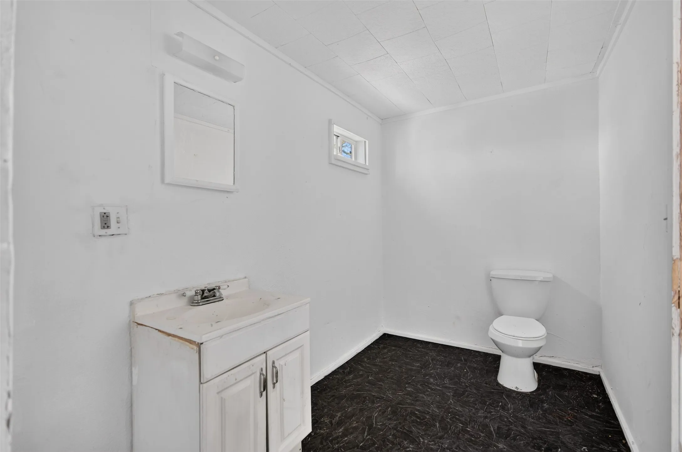 White vanity with dual-door storage, wall-mounted mirror, and overhead light fixture