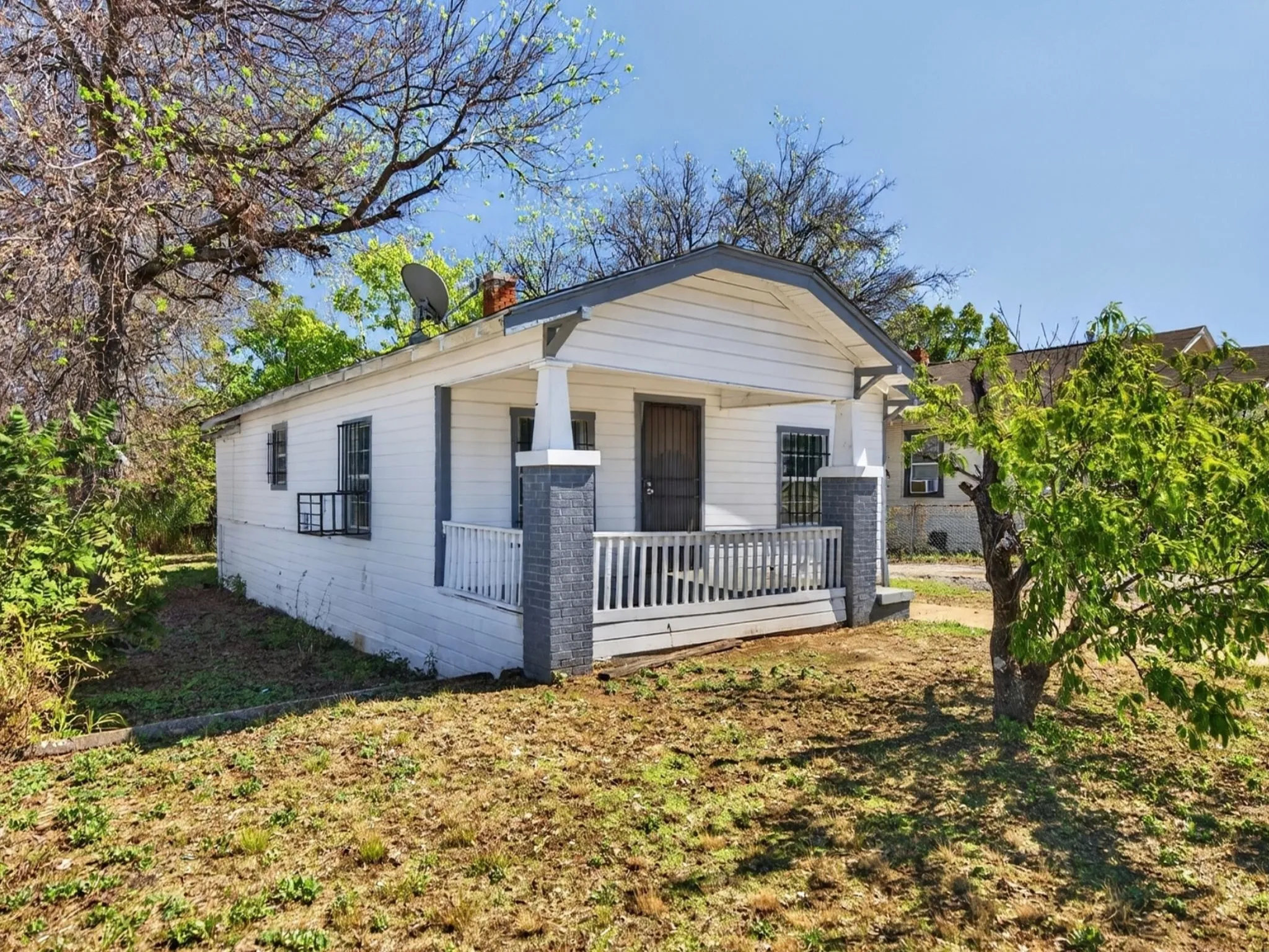 Front porch with white railings and gray-toned column supports