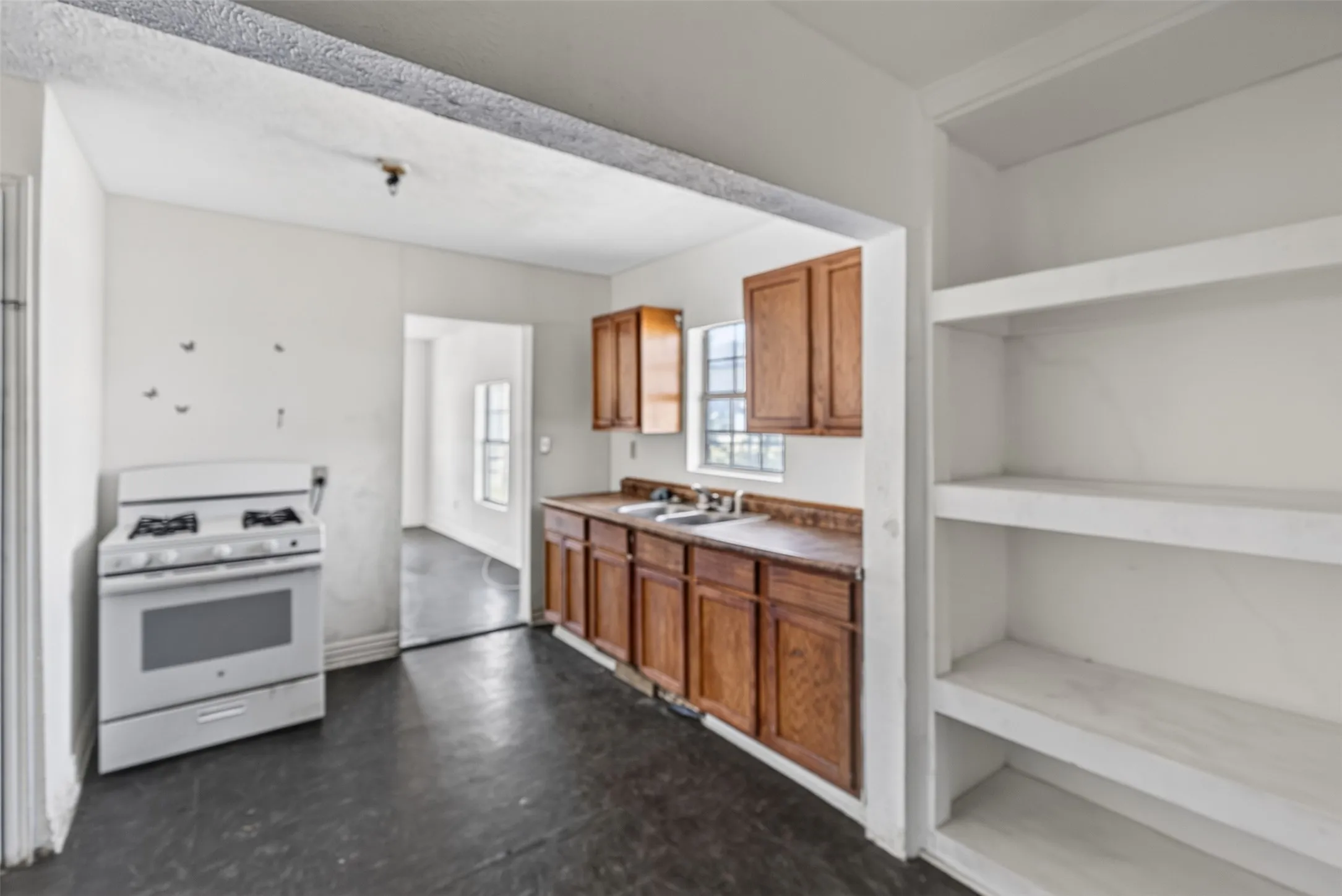 Built-in shelving, wood-finish cabinetry, and a gas range