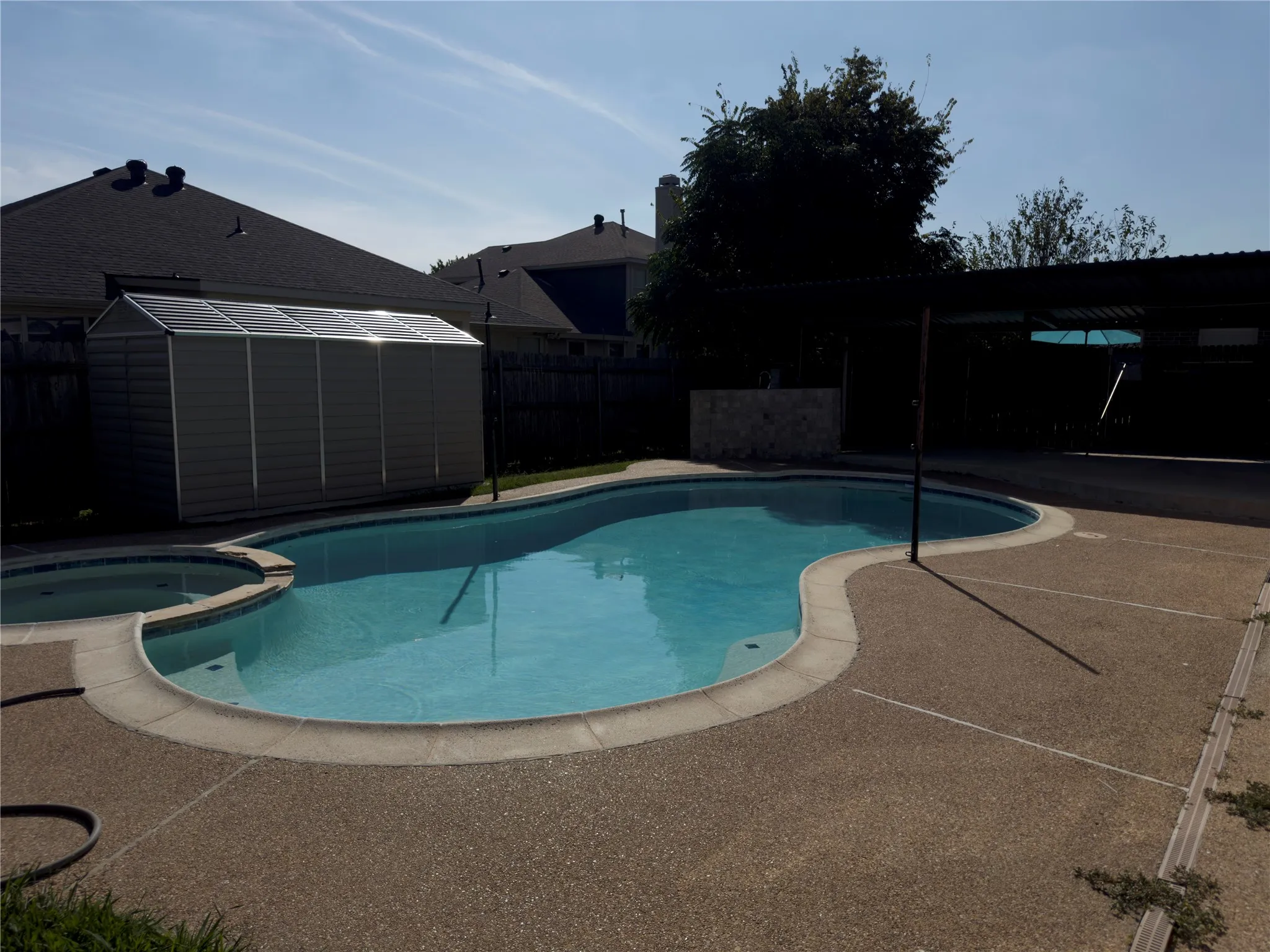 View of pool with a storage unit, a pool with connected hot tub, and a patio