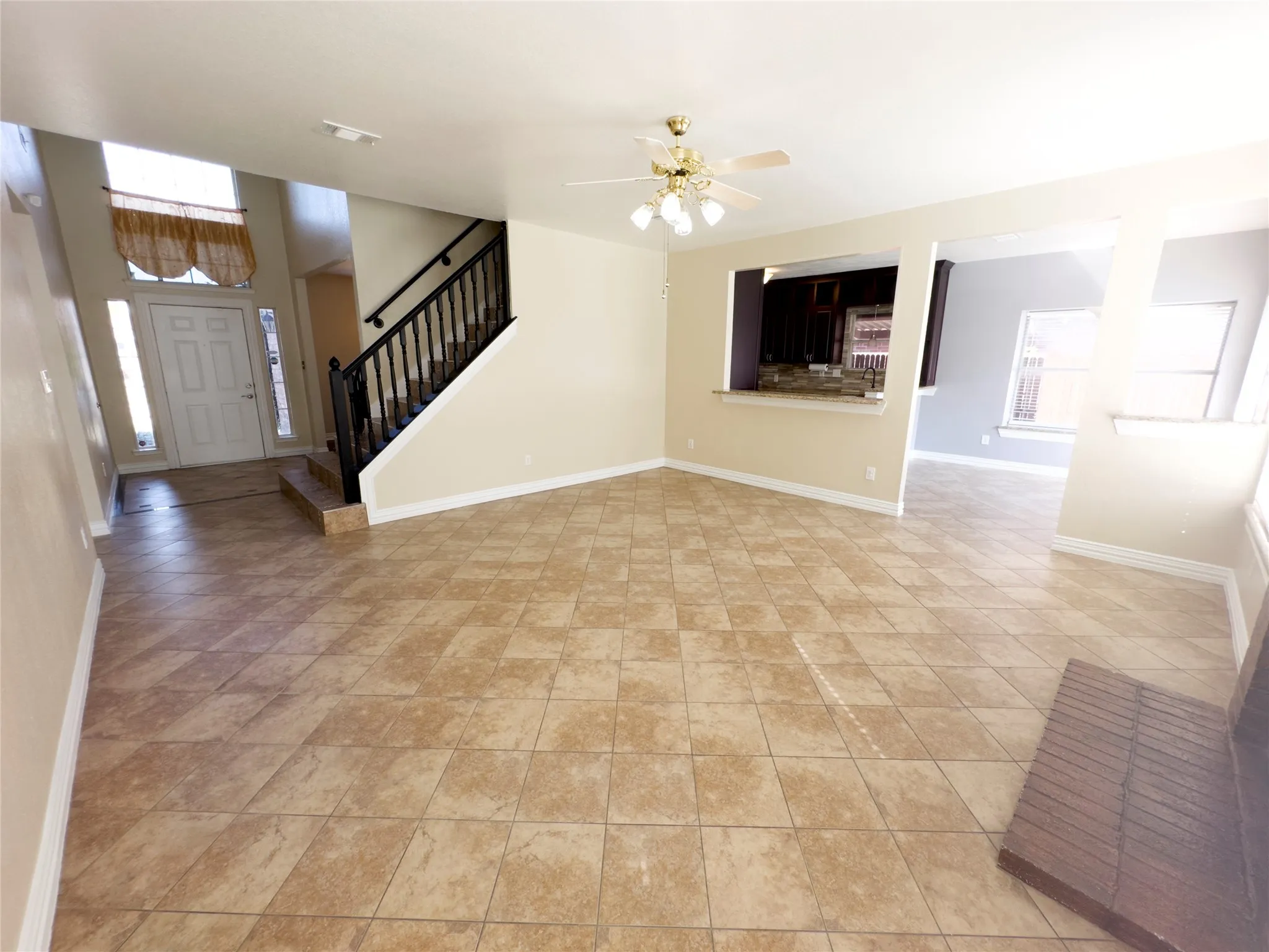Unfurnished living room featuring stairs and ceiling fan