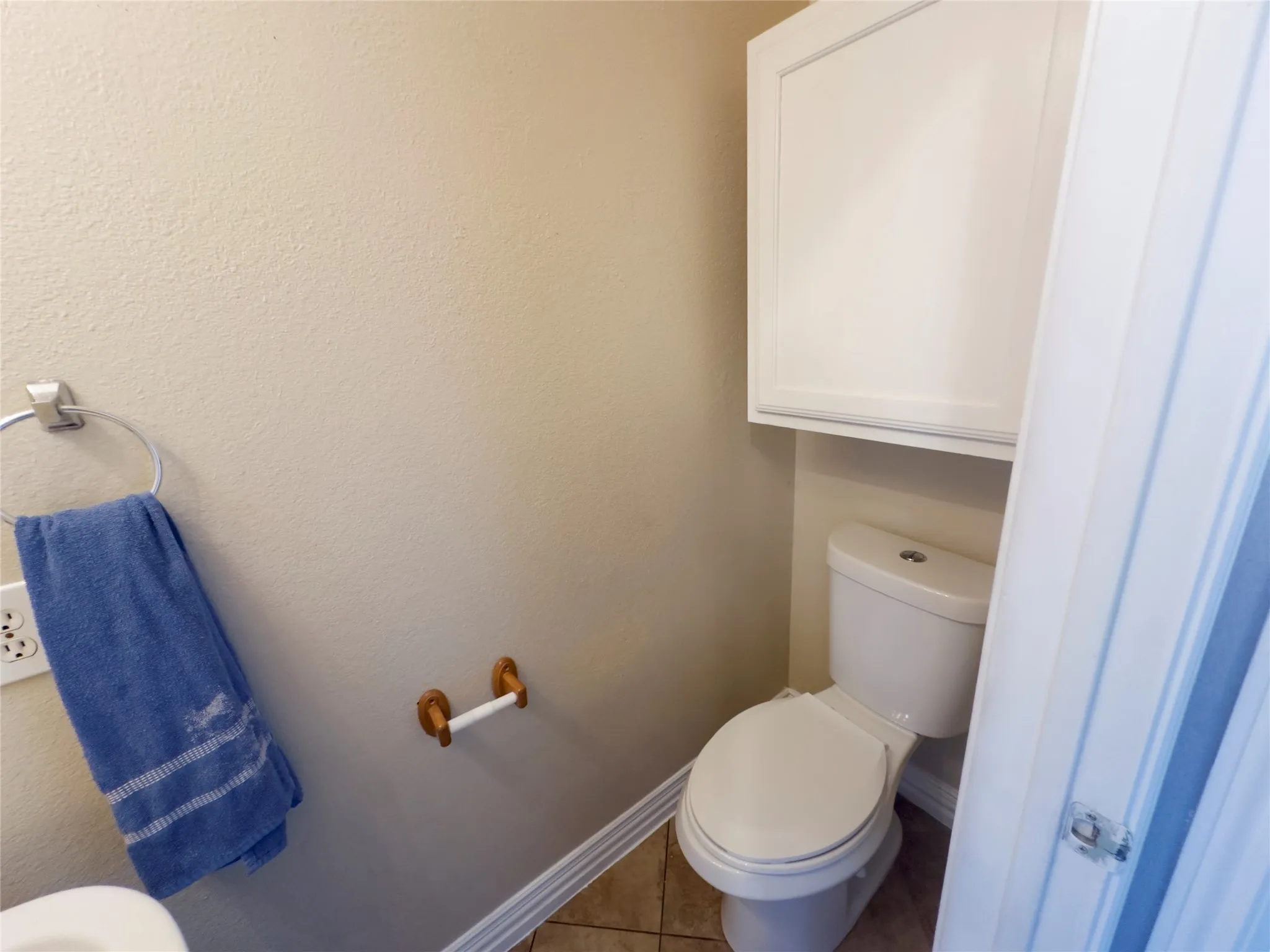 Bathroom with tile patterned floors and a textured wall
