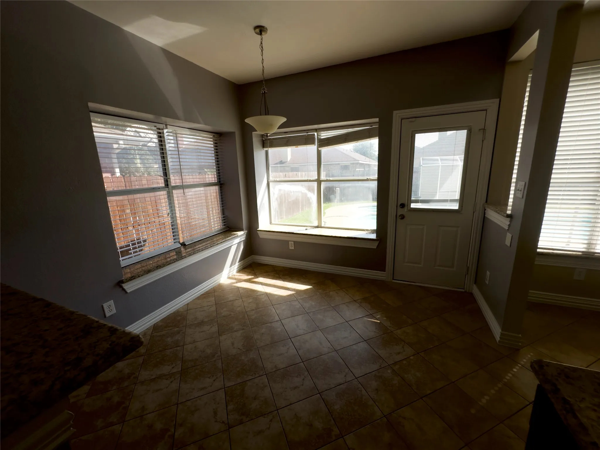 Unfurnished dining area featuring tile patterned flooring and baseboards