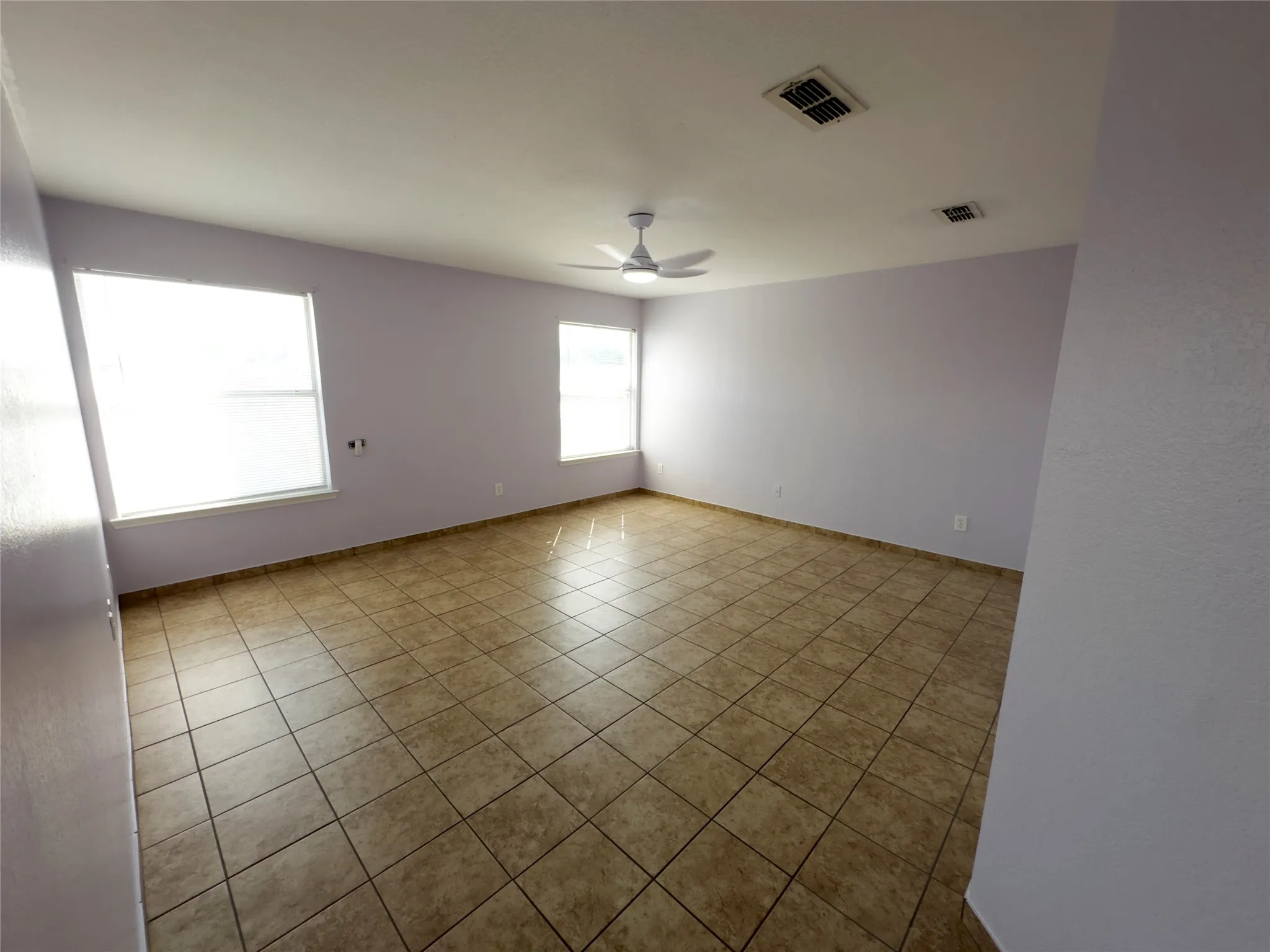Unfurnished room featuring ceiling fan and light tile patterned floors