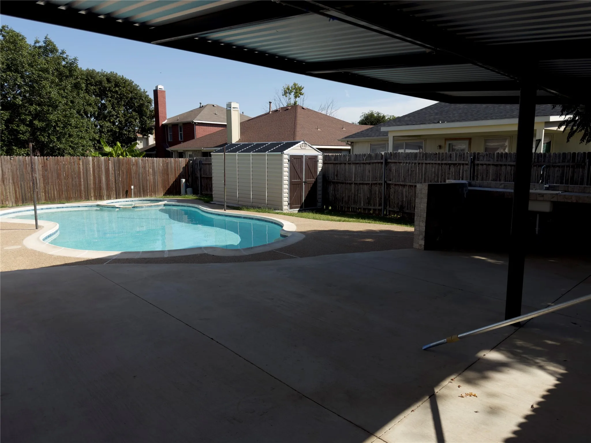 View of swimming pool featuring a fenced backyard, a shed, a patio, and a pool with connected hot tub