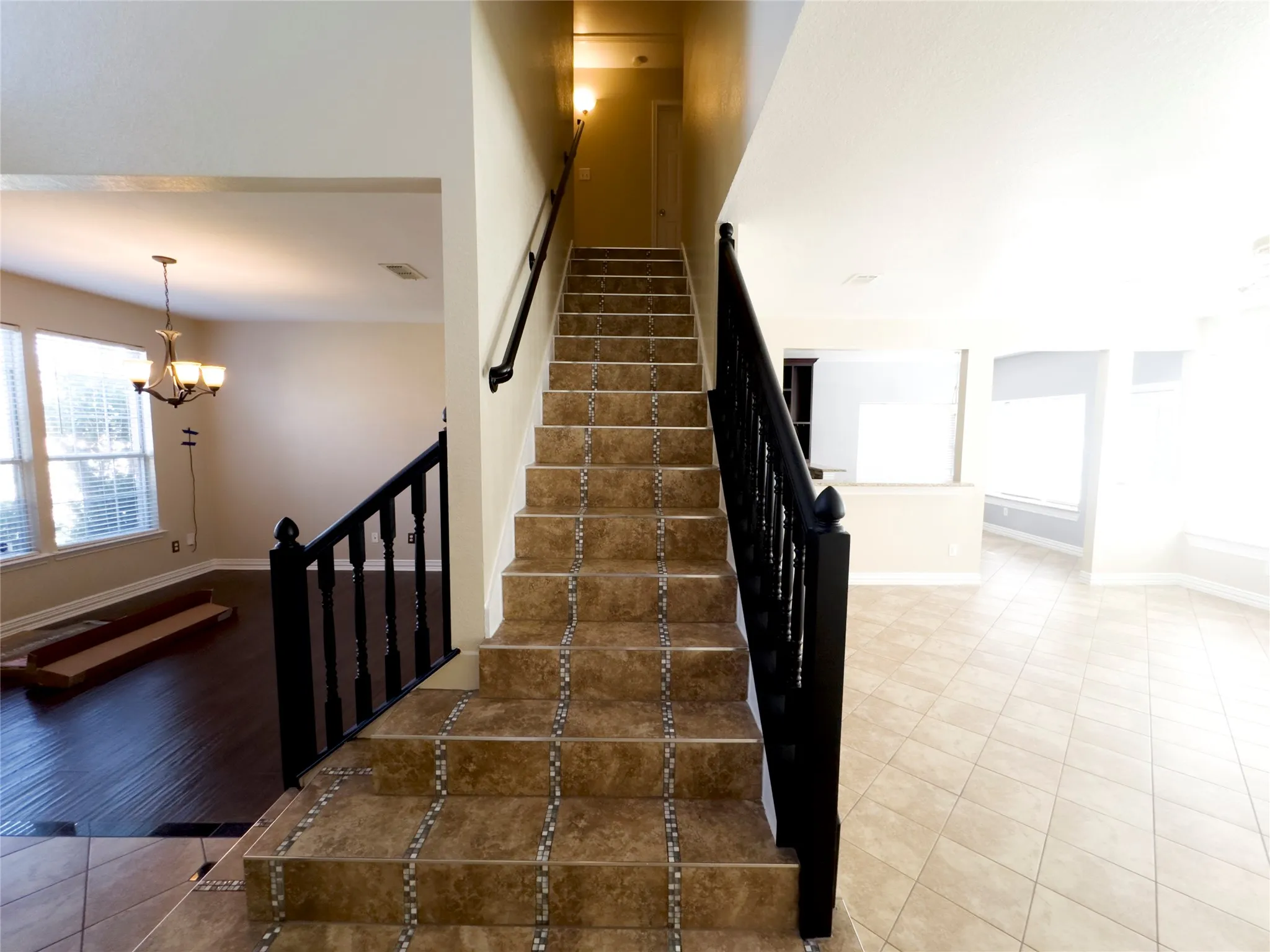 Stairway featuring a chandelier and tile patterned floors