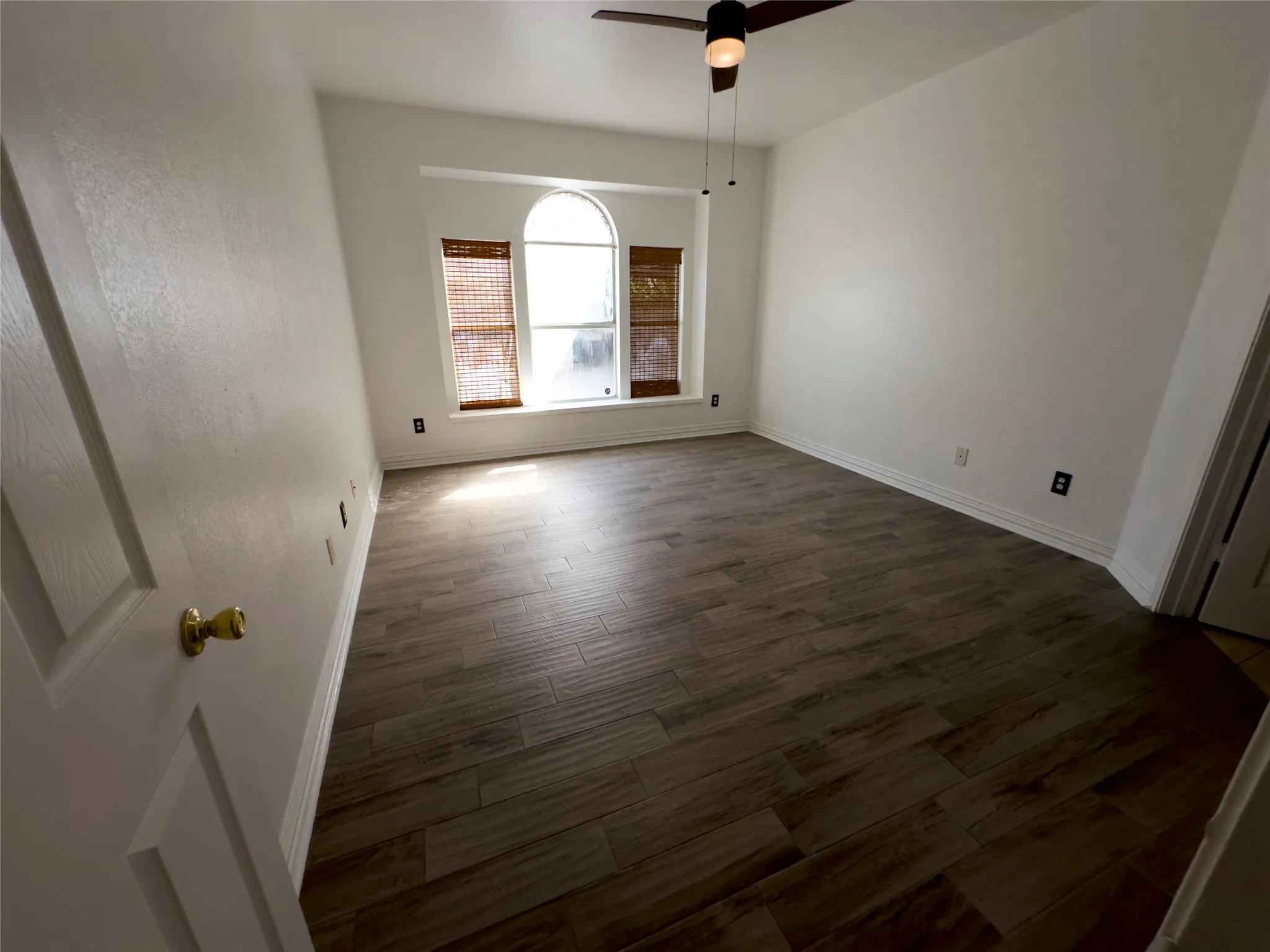 Unfurnished room with wood finished floors and ceiling fan