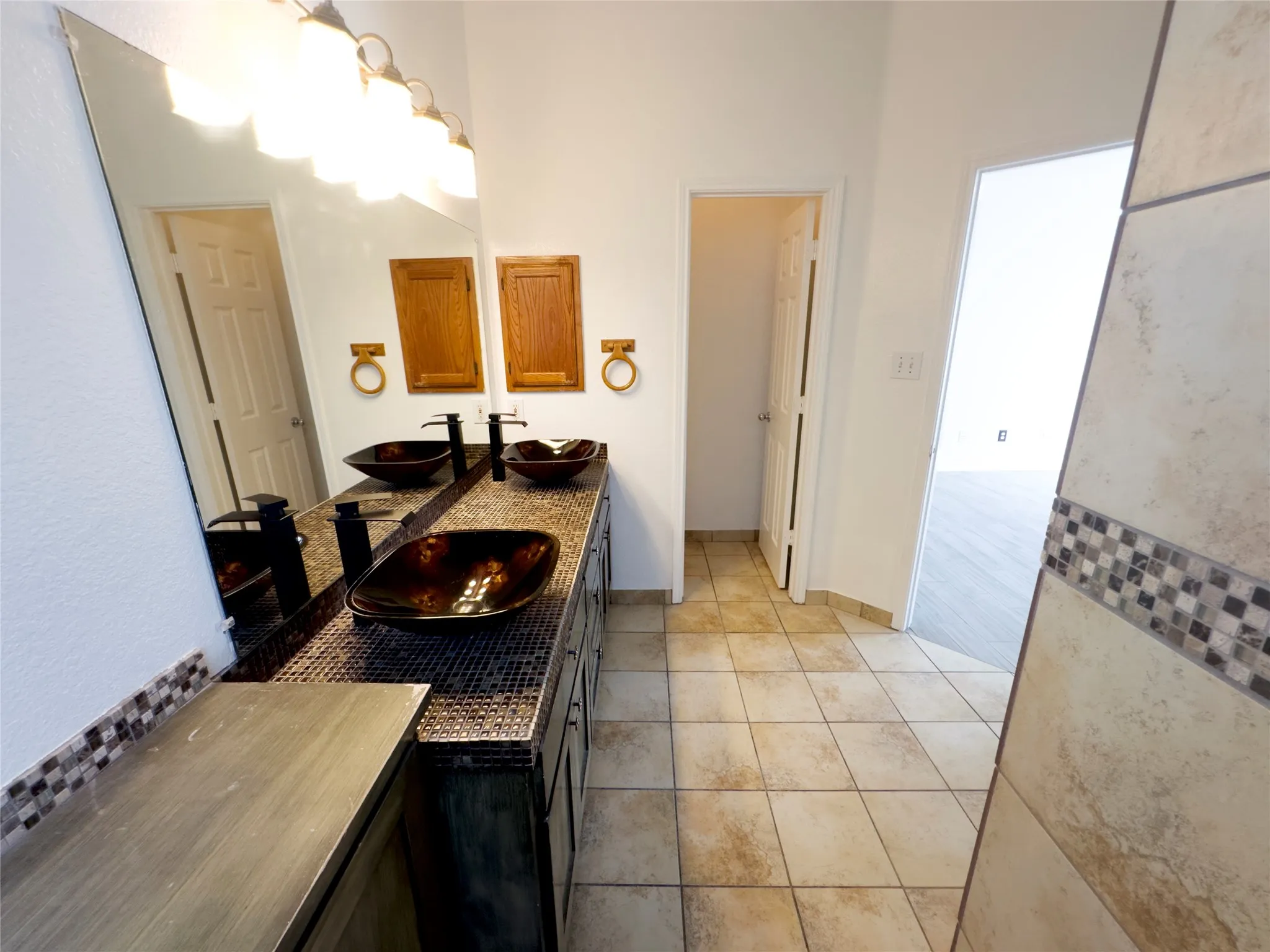Bathroom featuring light tile patterned flooring and double vanity