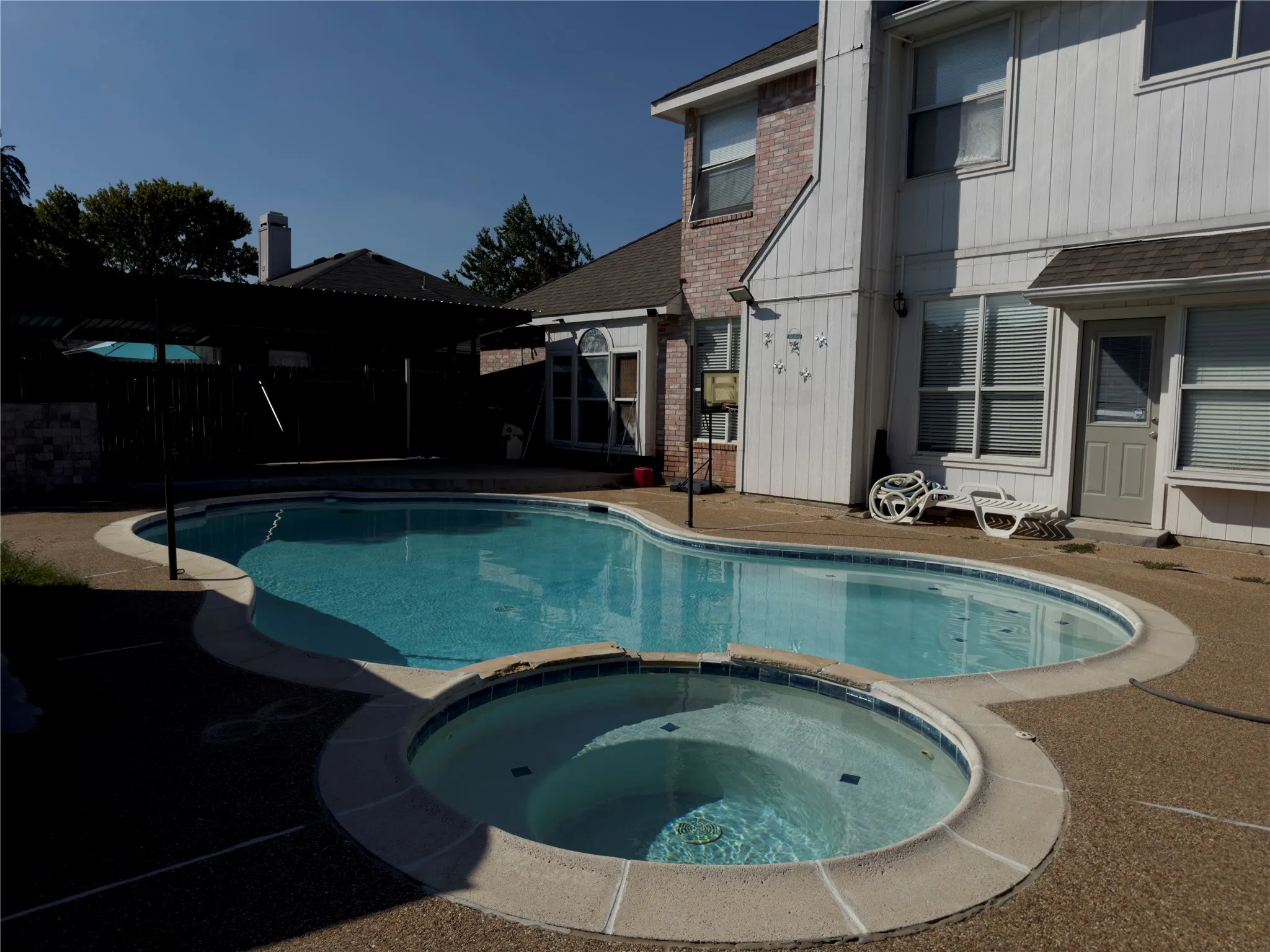 View of swimming pool with a patio area and a pool with connected hot tub