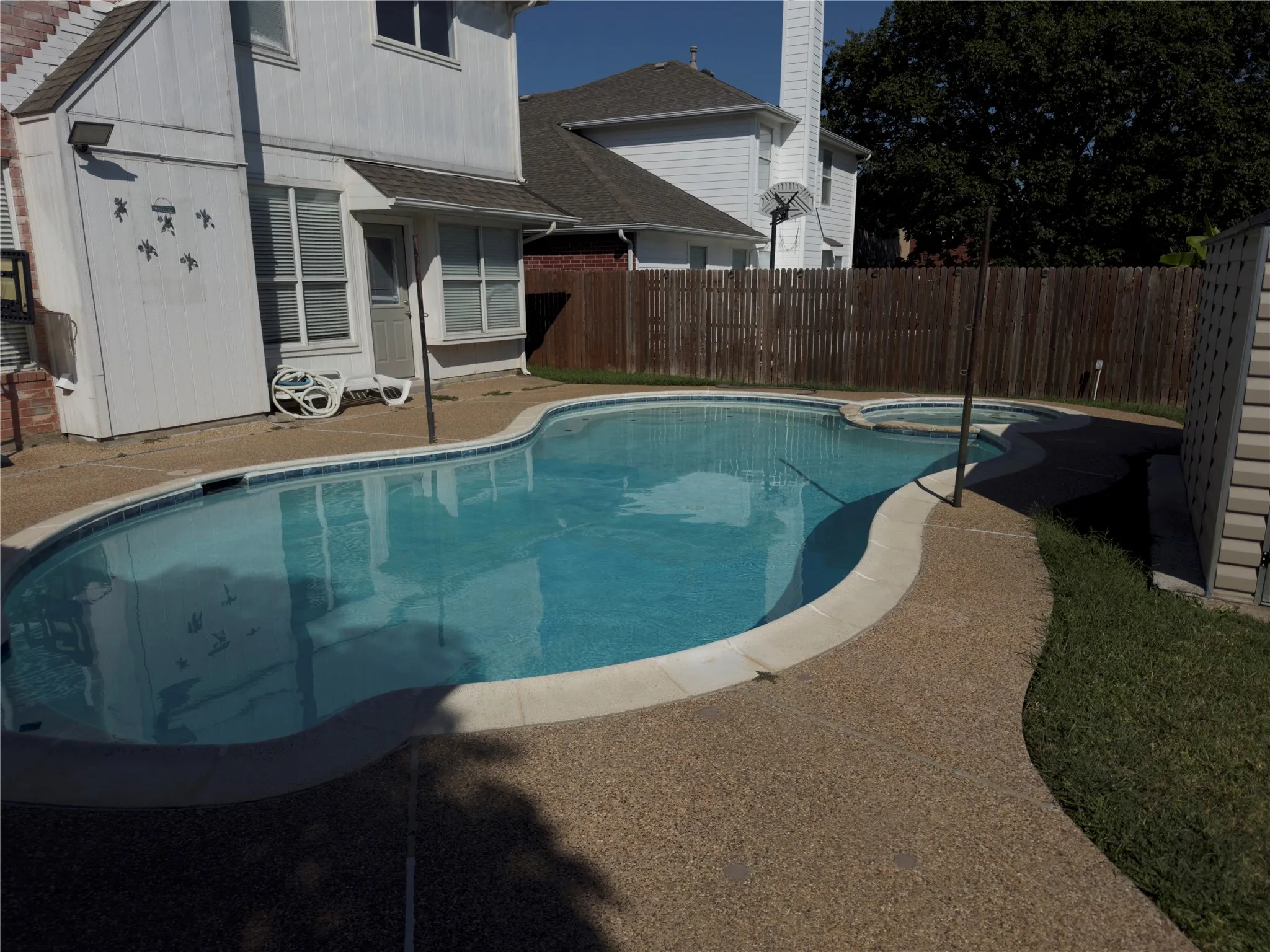 View of swimming pool featuring a patio and a pool with connected hot tub