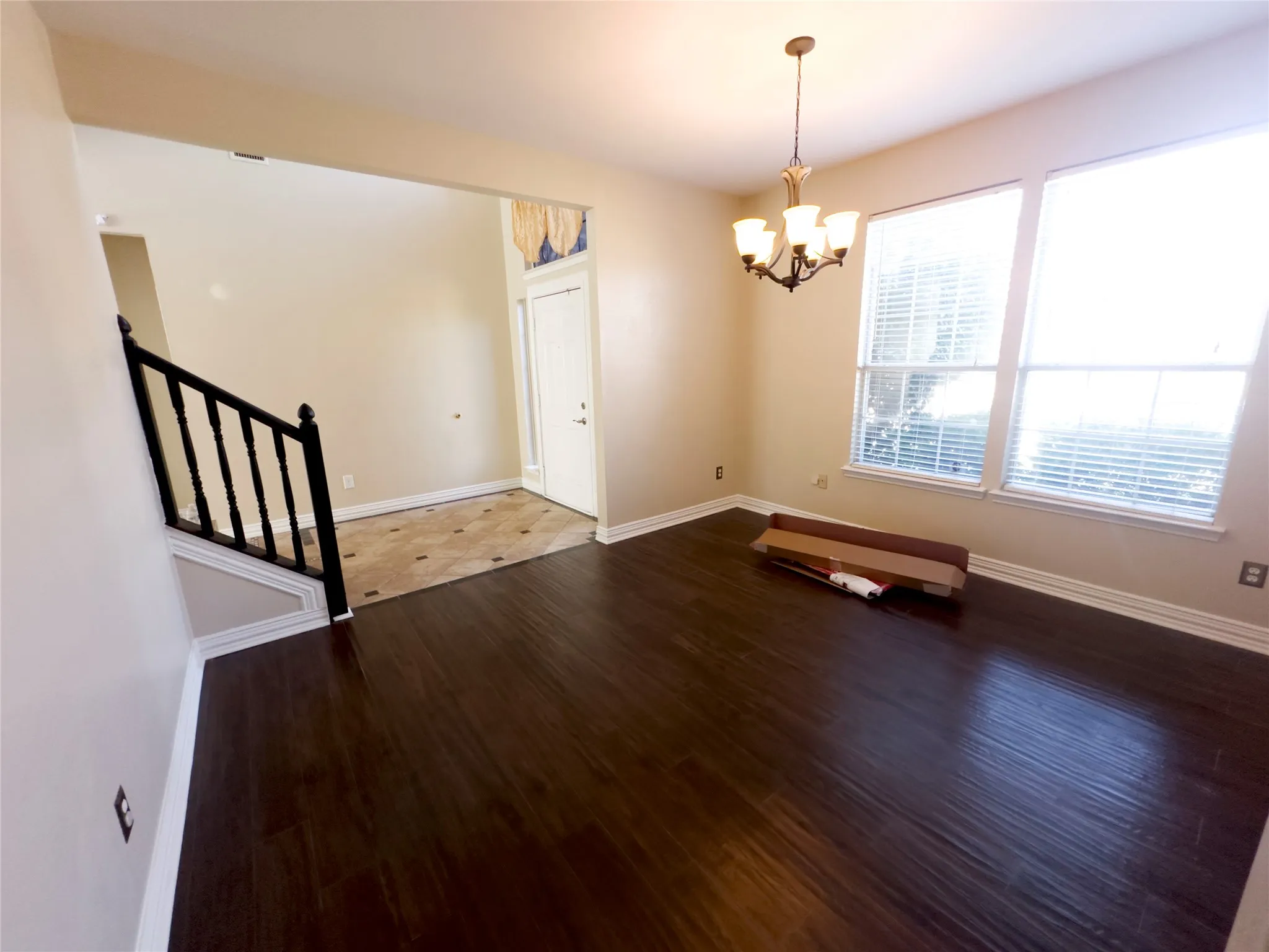 Unfurnished dining area featuring stairs, dark wood-style floors, and a chandelier