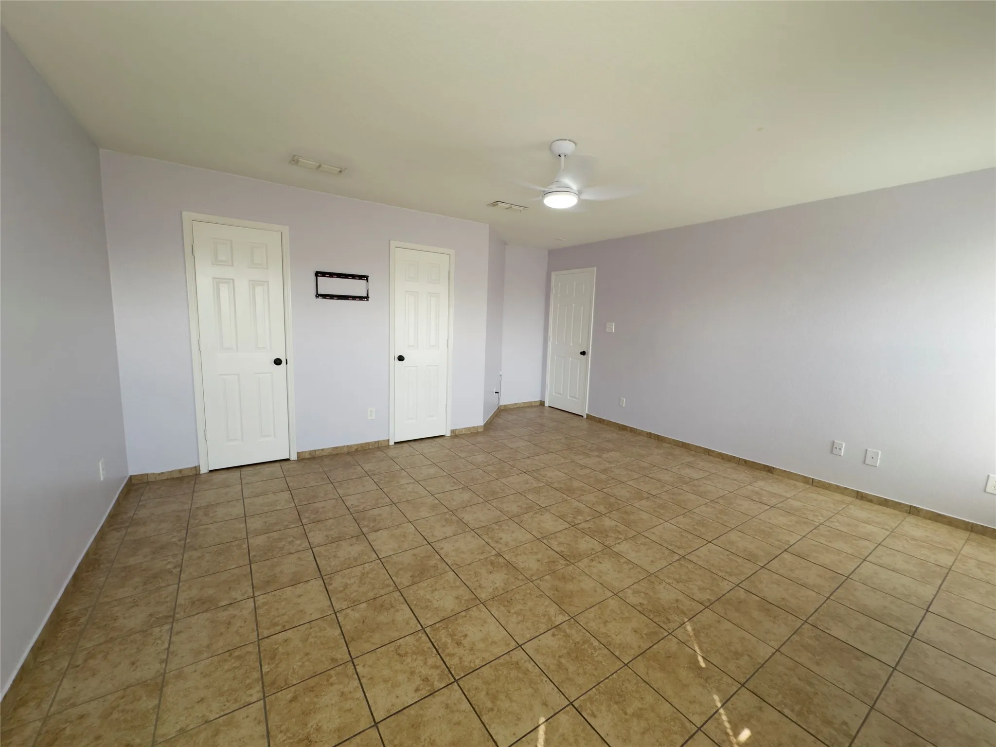 Spare room with light tile patterned floors and ceiling fan