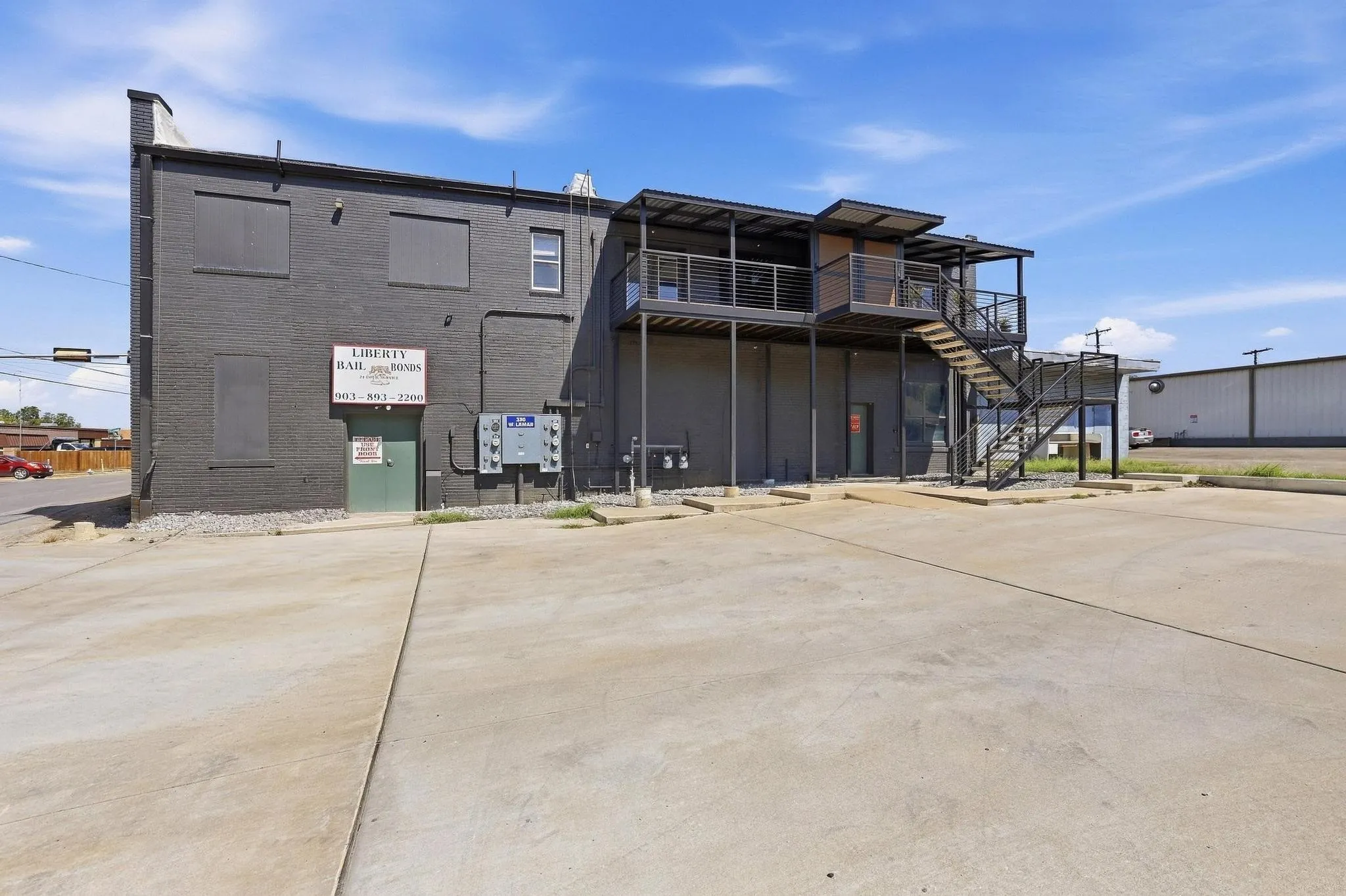 Two-story commercial building with an exterior metal staircase and multiple entrances