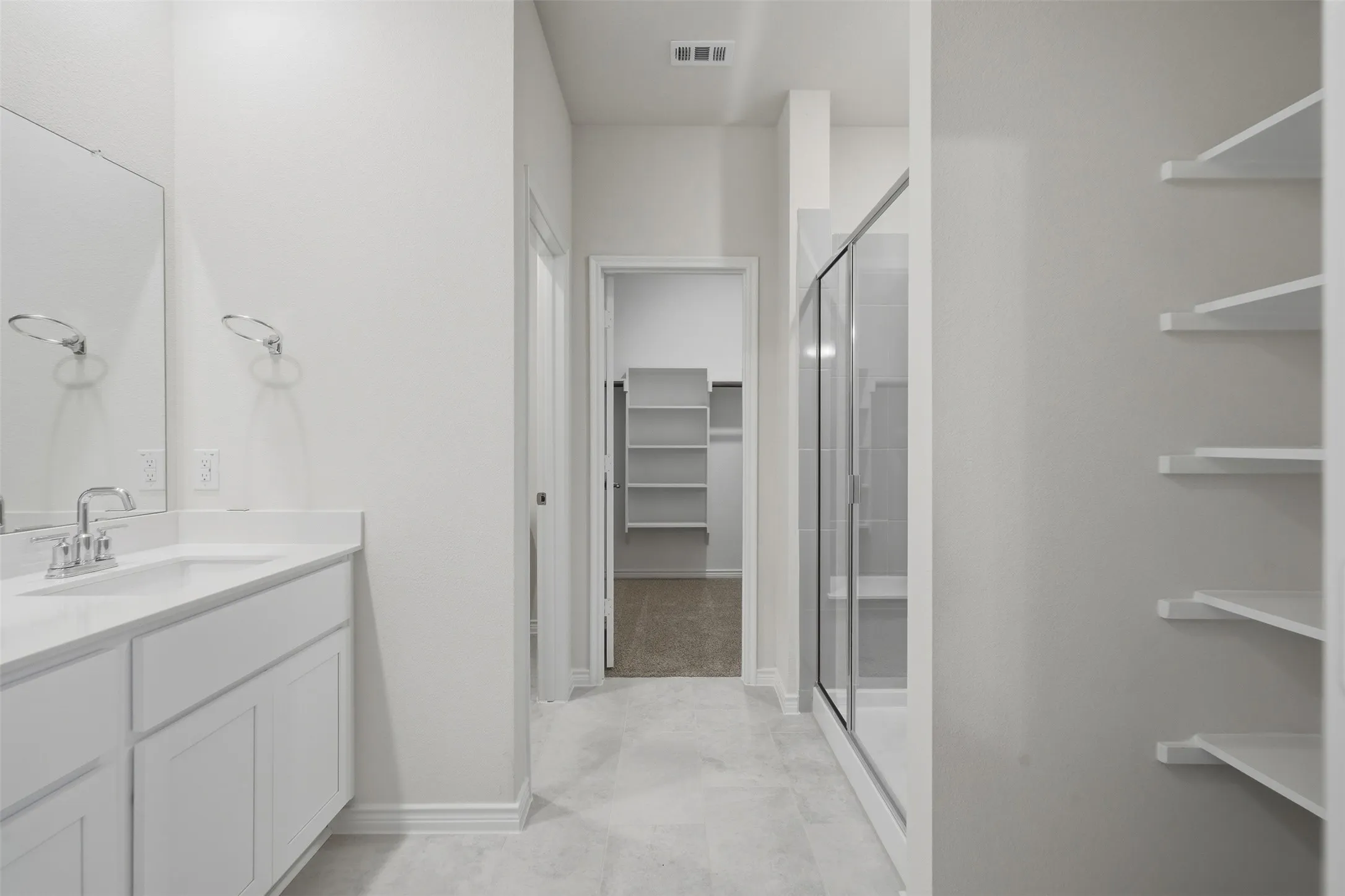 White vanity with a single basin, chrome fixtures, and a large mirror