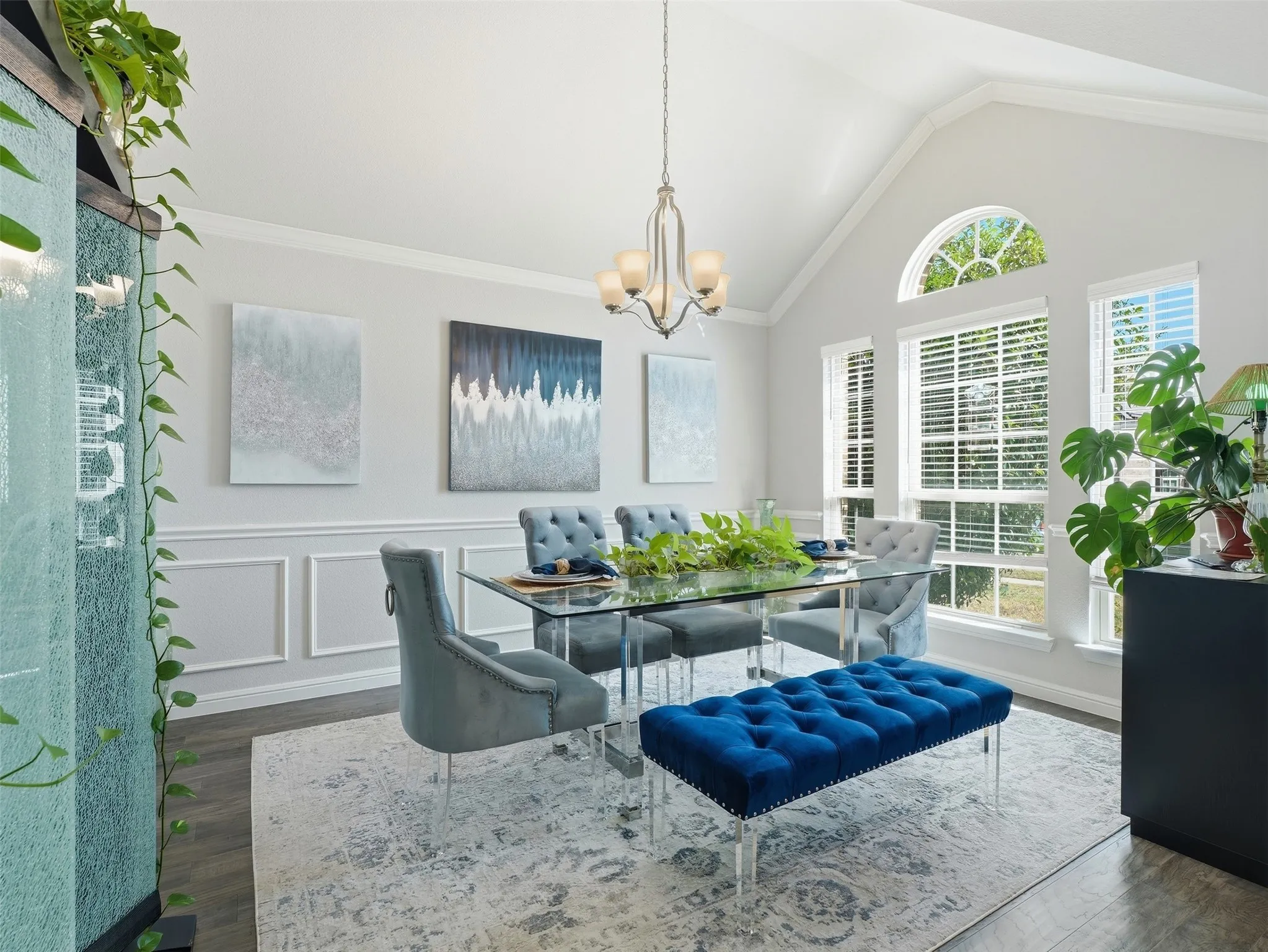 Vaulted ceiling, arched transom window, wood-finish flooring, wainscoting, and chandelier