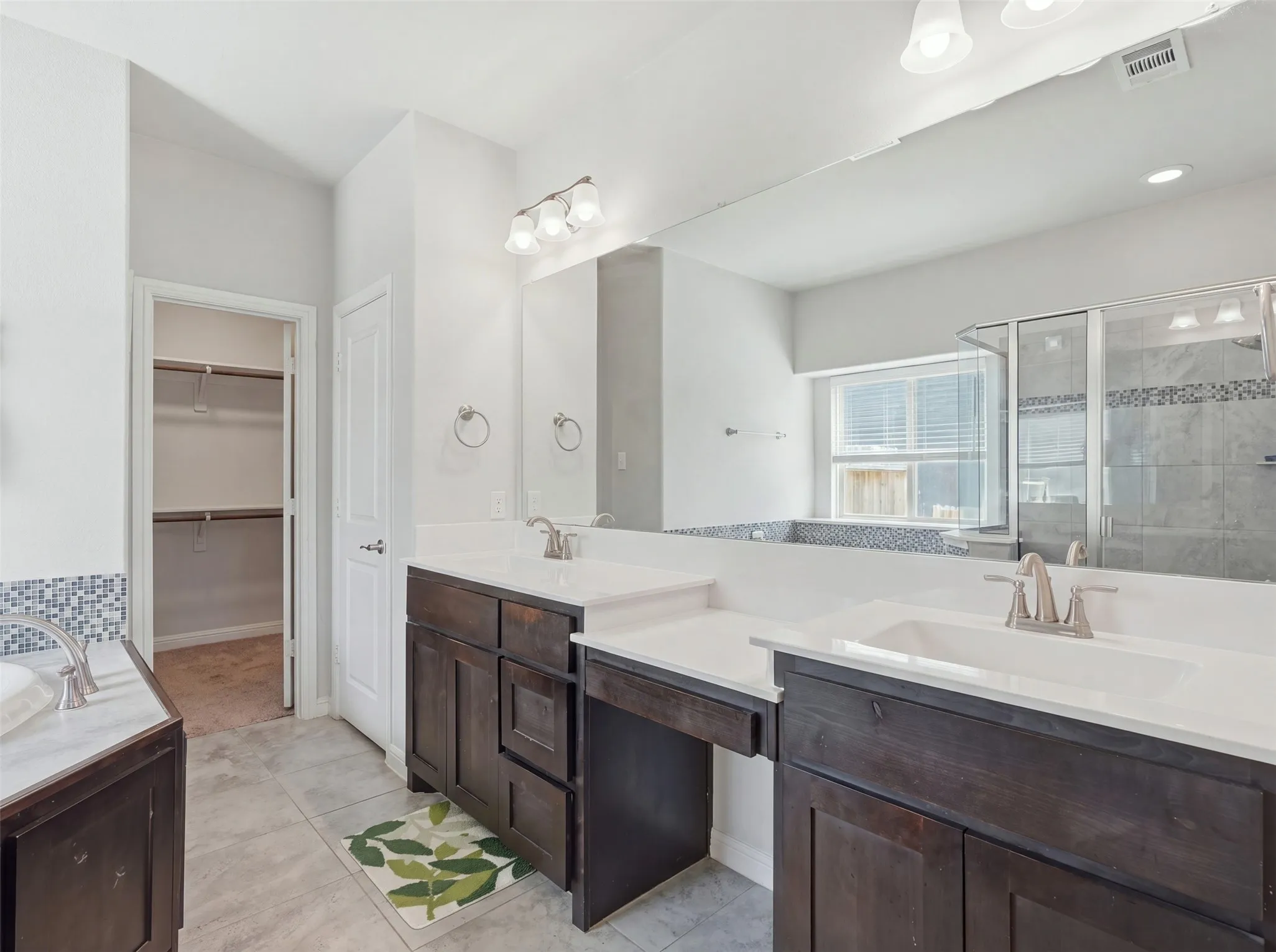 Dual vanity with white countertops and dark wood-finish cabinetry