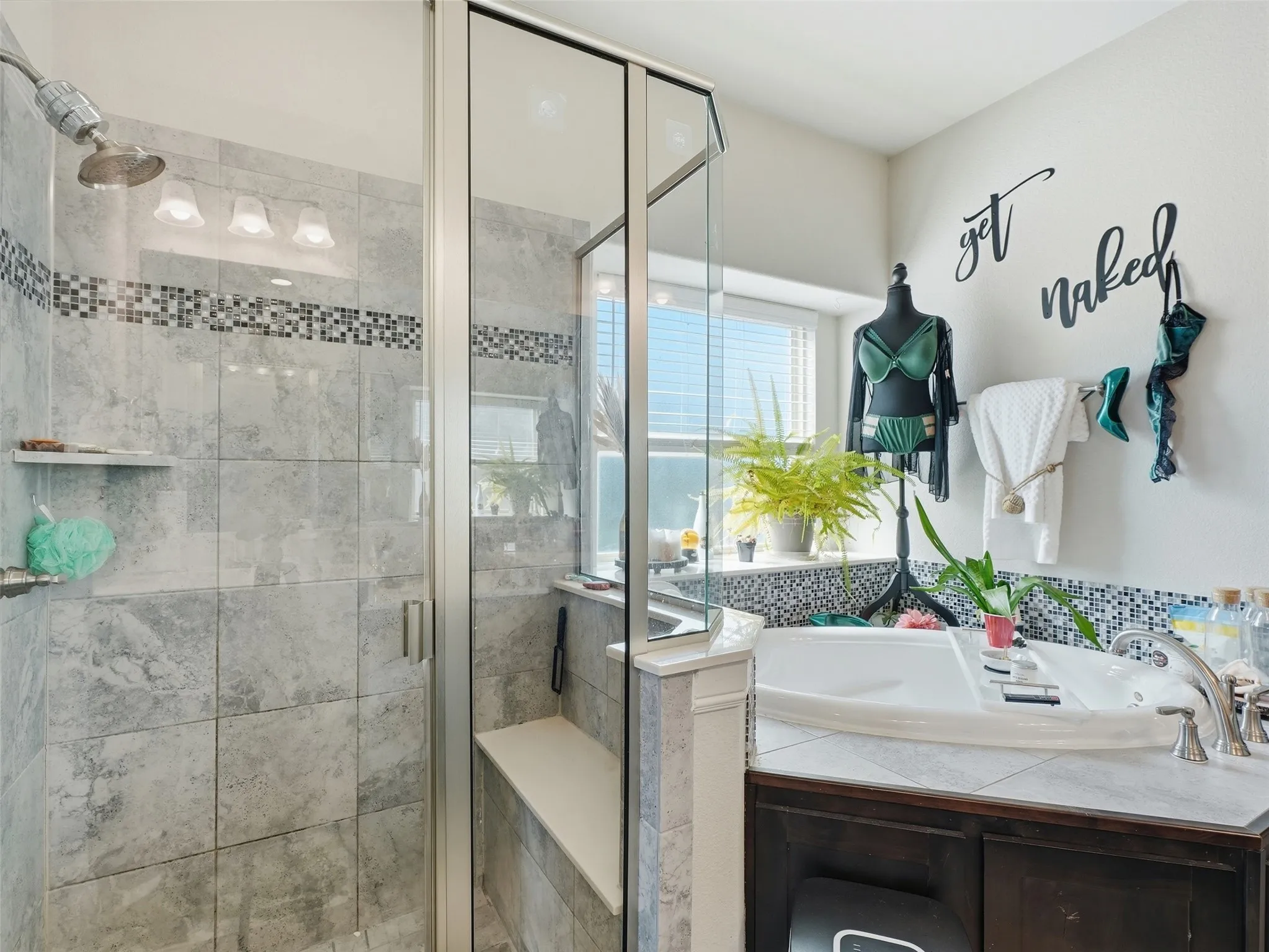 Glass-enclosed shower with tiled walls and built-in bench